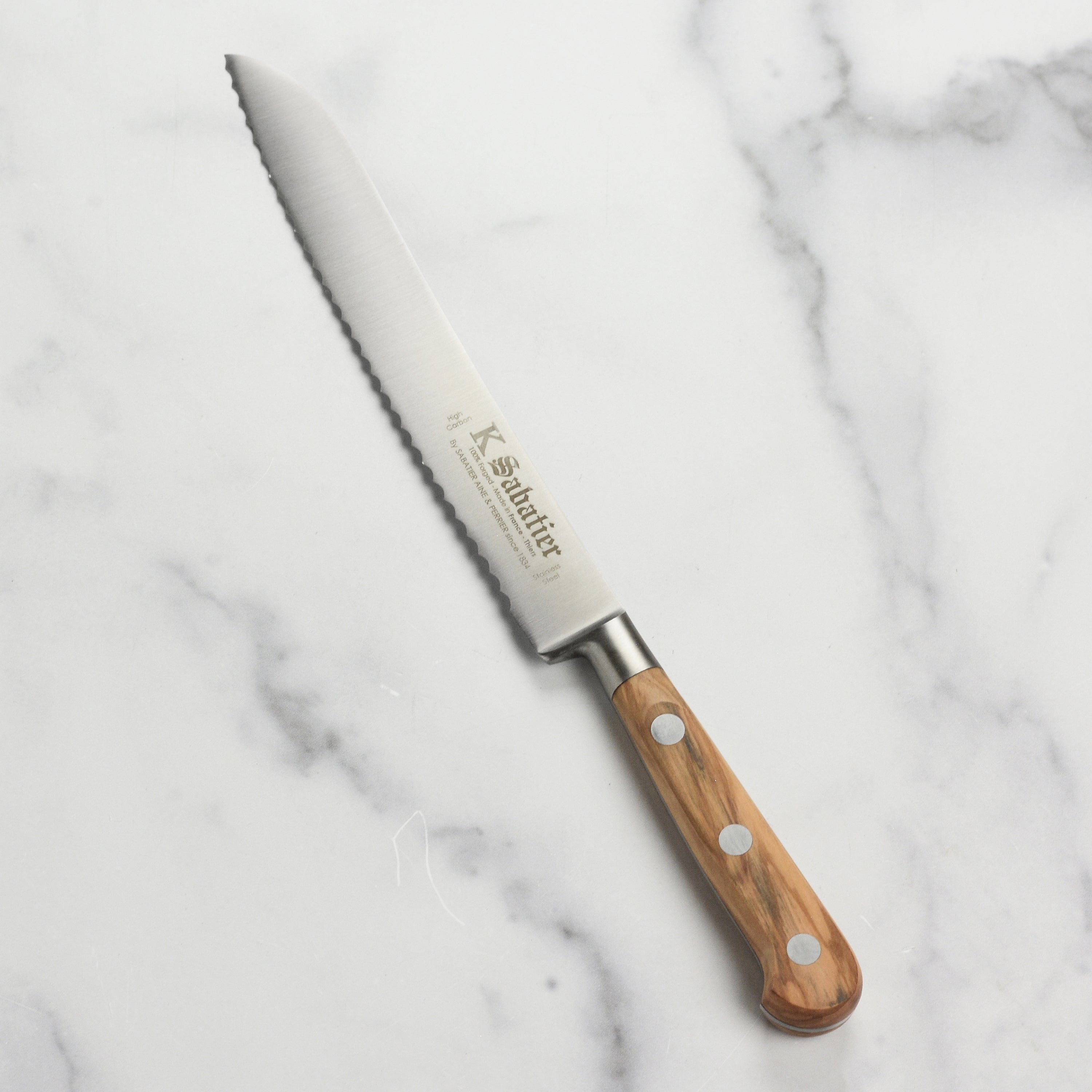 K Sabatier olive wood bread knife with a sleek stainless steel blade and comfortable handle.