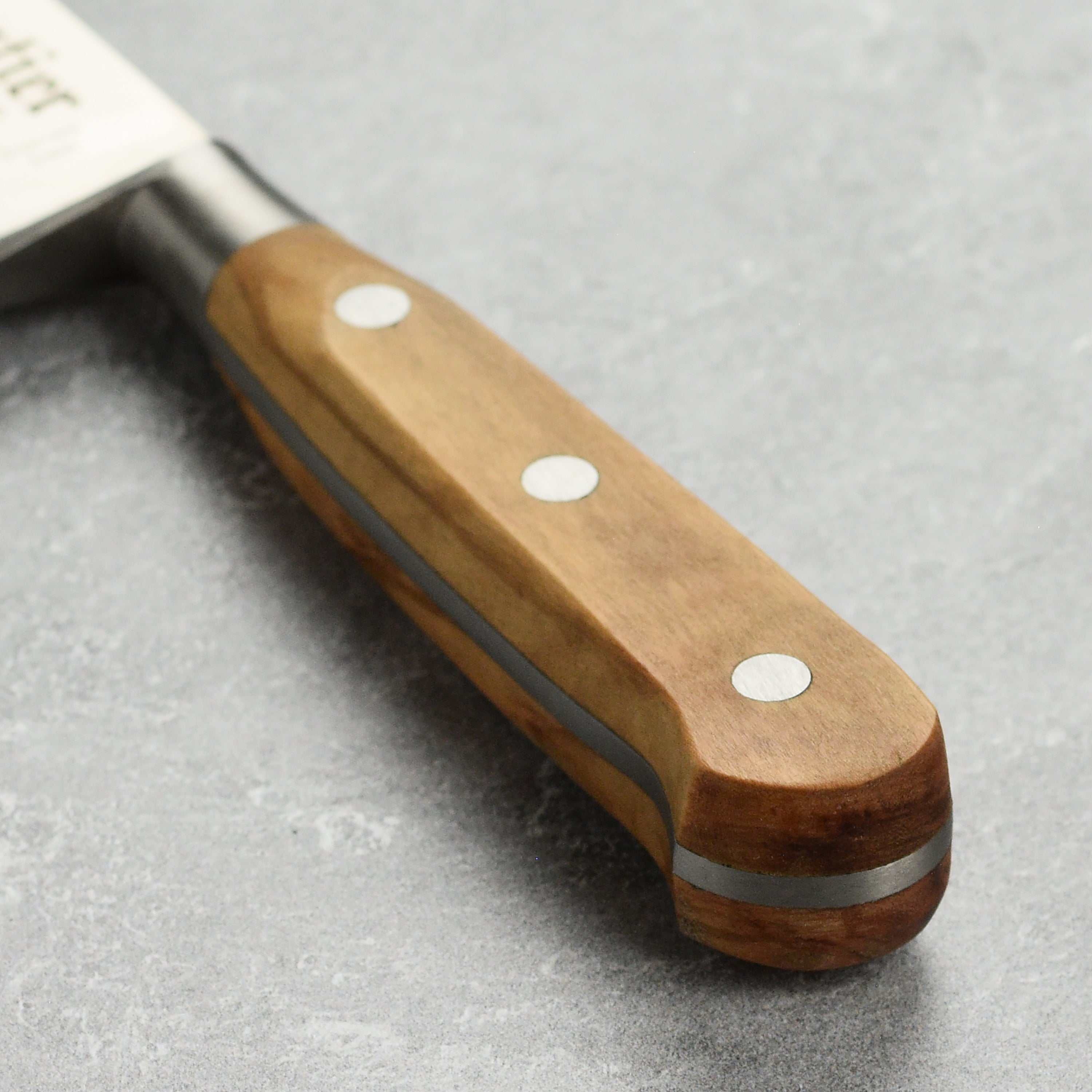 K Sabatier Premium Olive Wood Chefs Knife in action, slicing fresh vegetables on a wooden cutting board.
