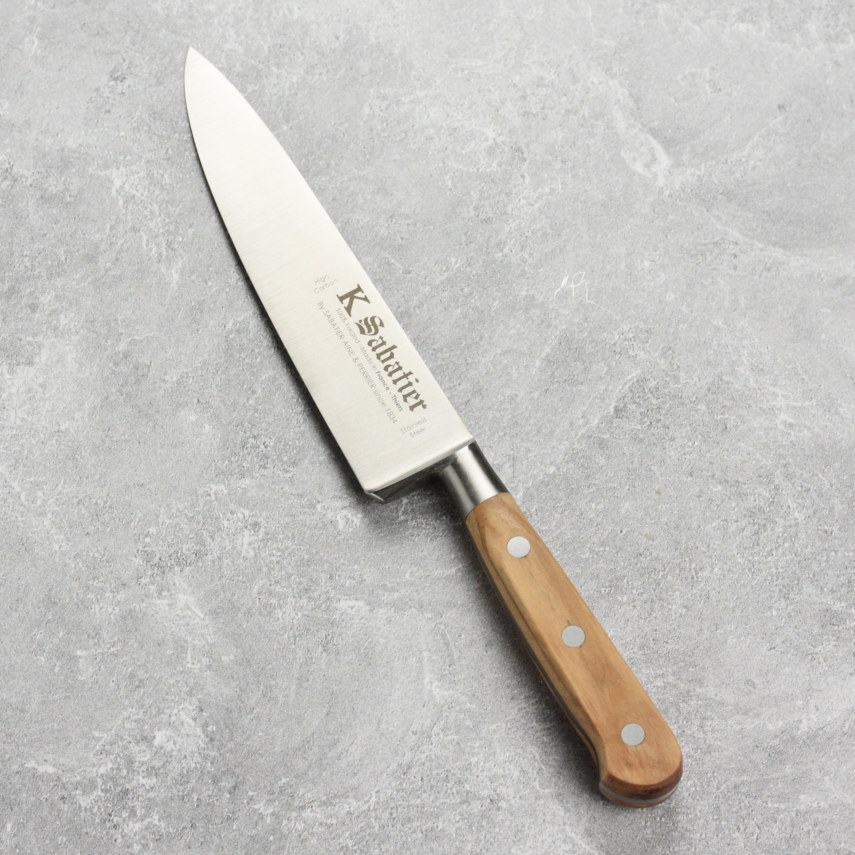 Side view of the K Sabatier Premium Olive Wood Chefs Knife displaying its full-tang construction and classic French-style bolster.