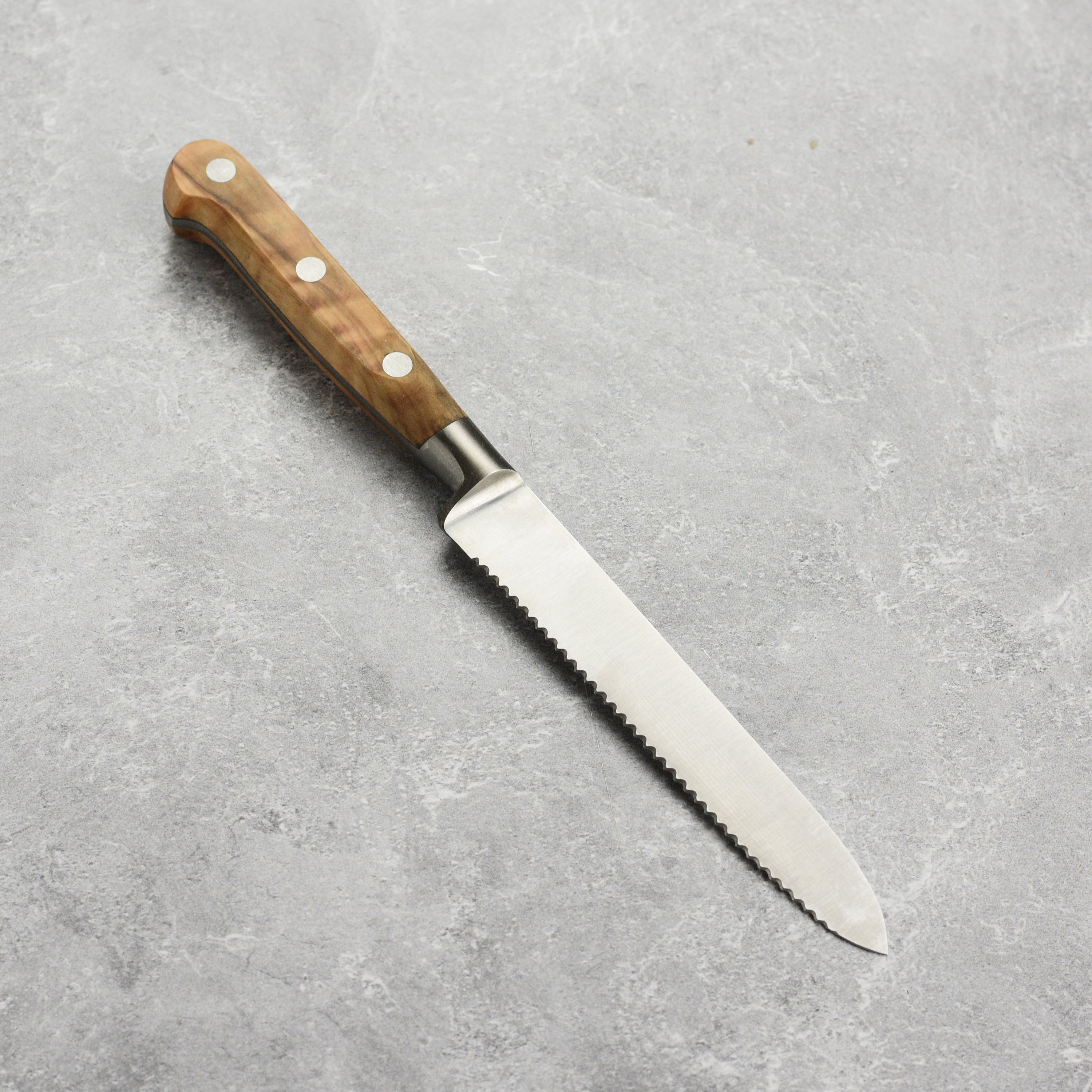 Premium tomato knife for chefs slicing ripe tomatoes on a wooden cutting board