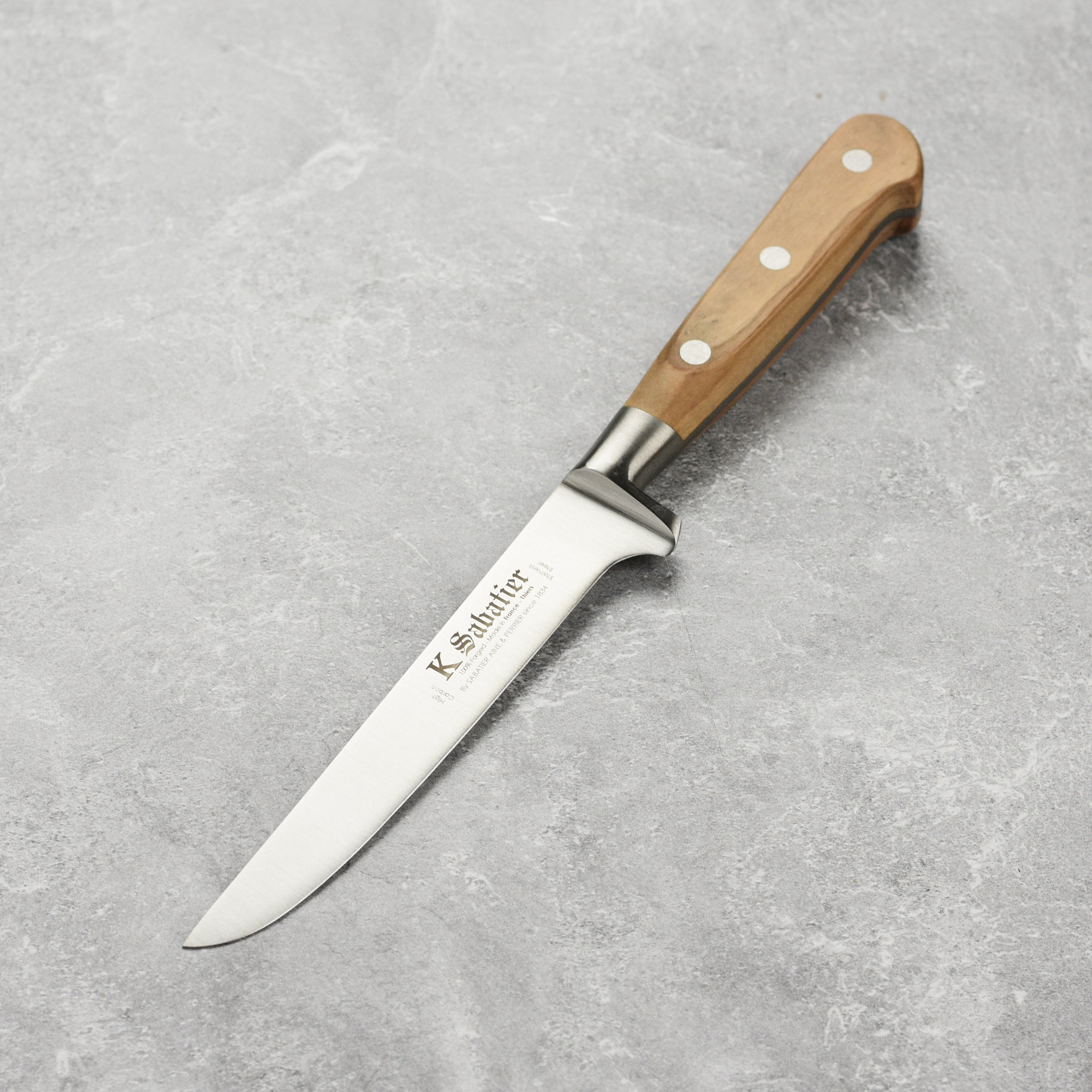 Sabatier Olive Wood Boning Knife showcasing the stainless steel blade and olive wood handle from a side angle