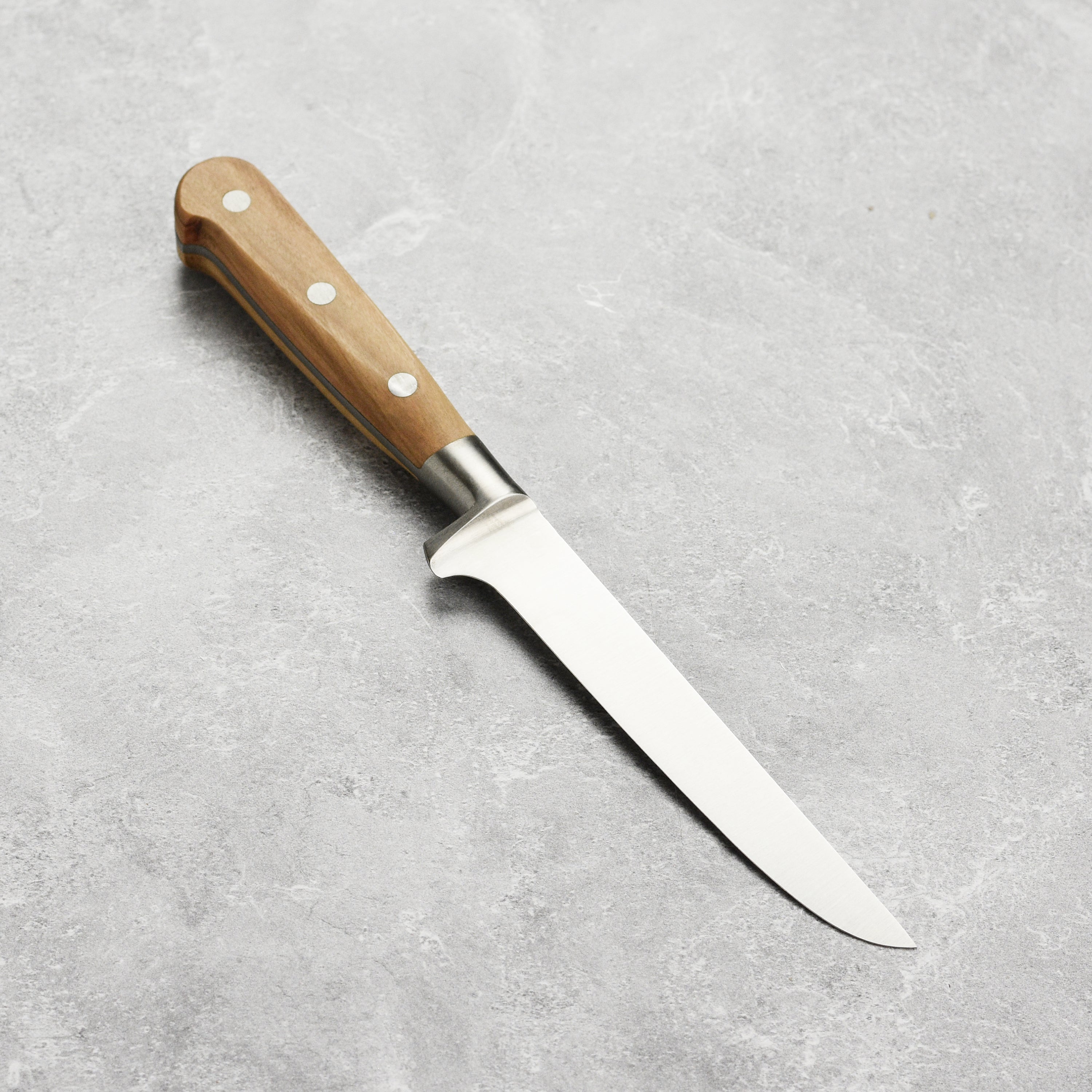 Close-up of the Sabatier Olive Wood Boning Knife highlighting the full-tang design and classic bolster