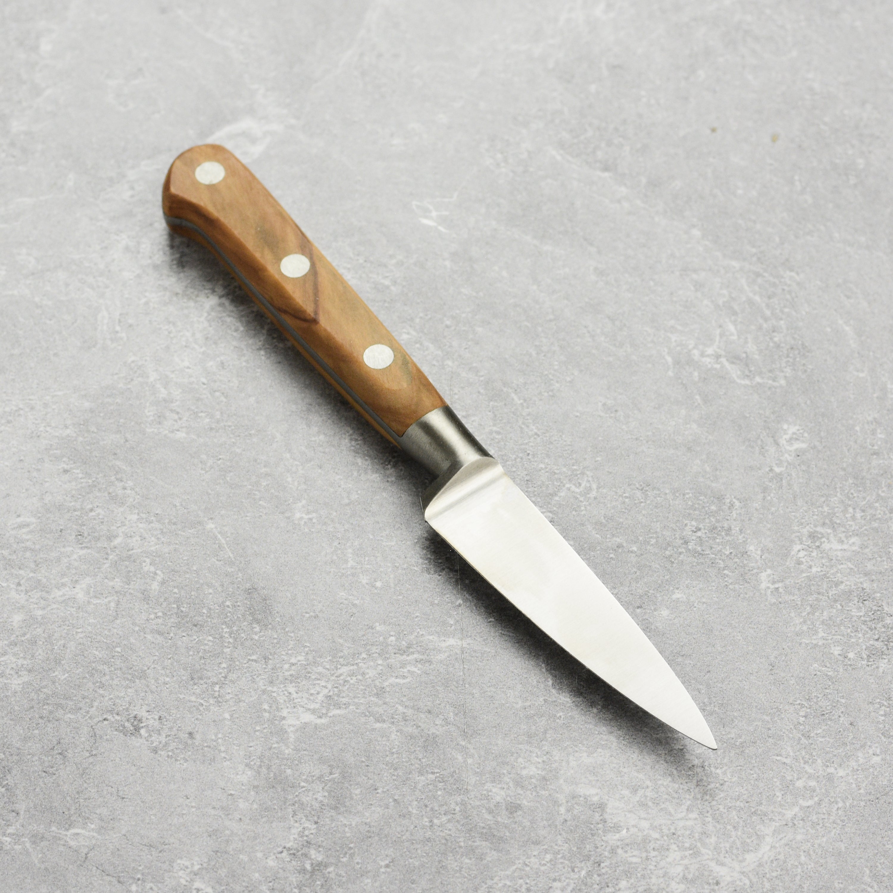 Close-up of the K Sabatier paring knifes stainless steel blade and classic bolster.