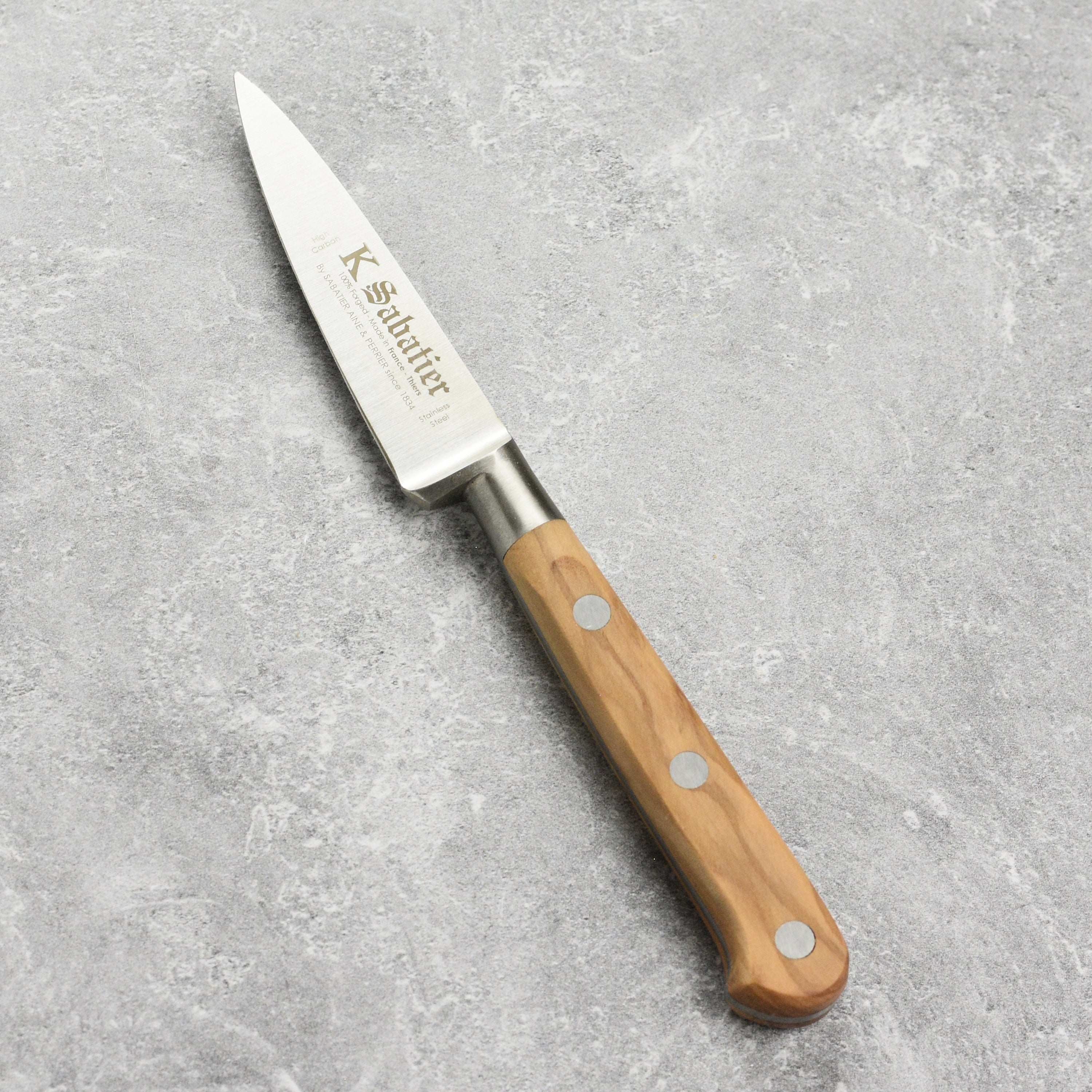 K Sabatier paring knife in action, expertly slicing fresh vegetables.