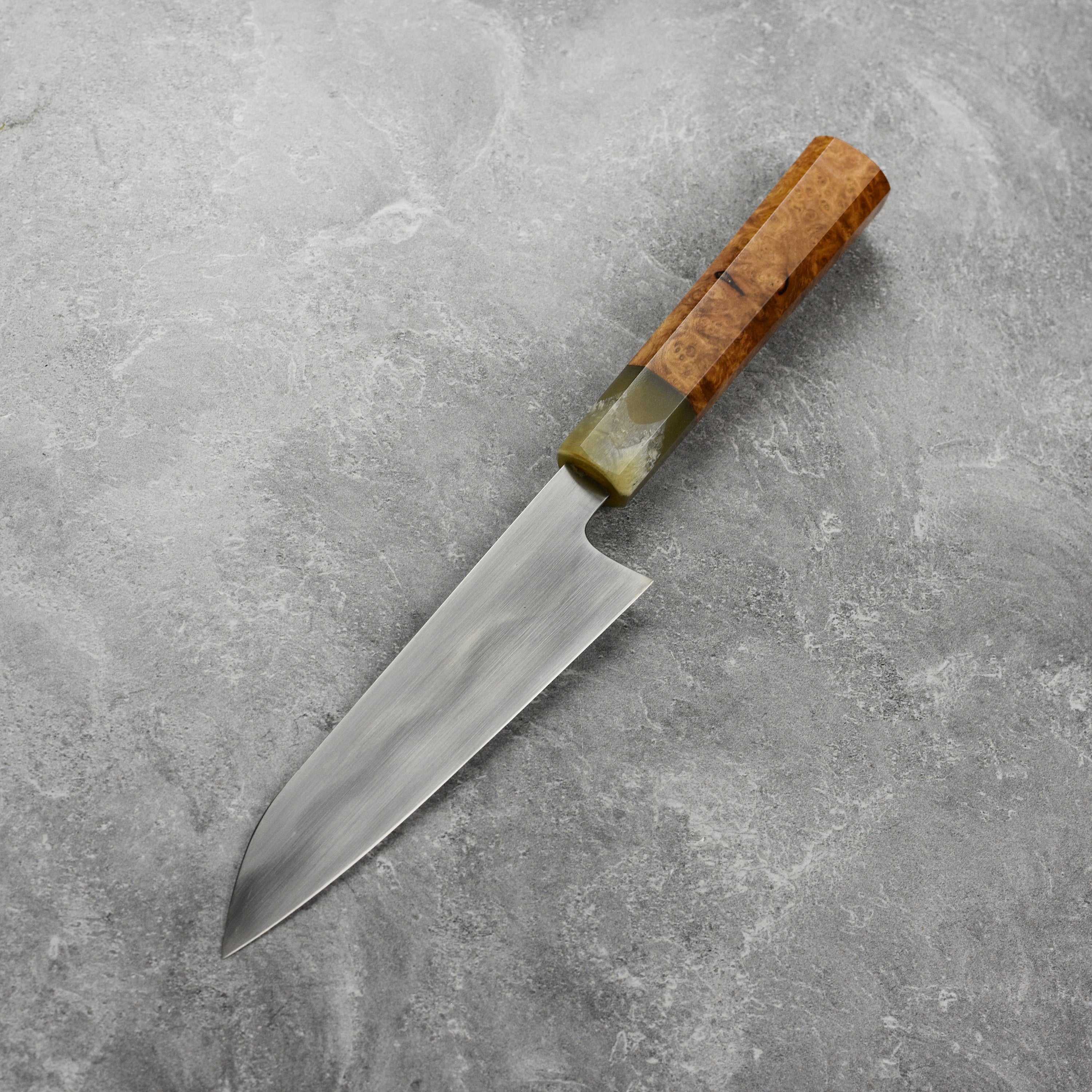 Hand-forged carbon steel petty knife with saya, showcasing sharp blade and ergonomic handle.