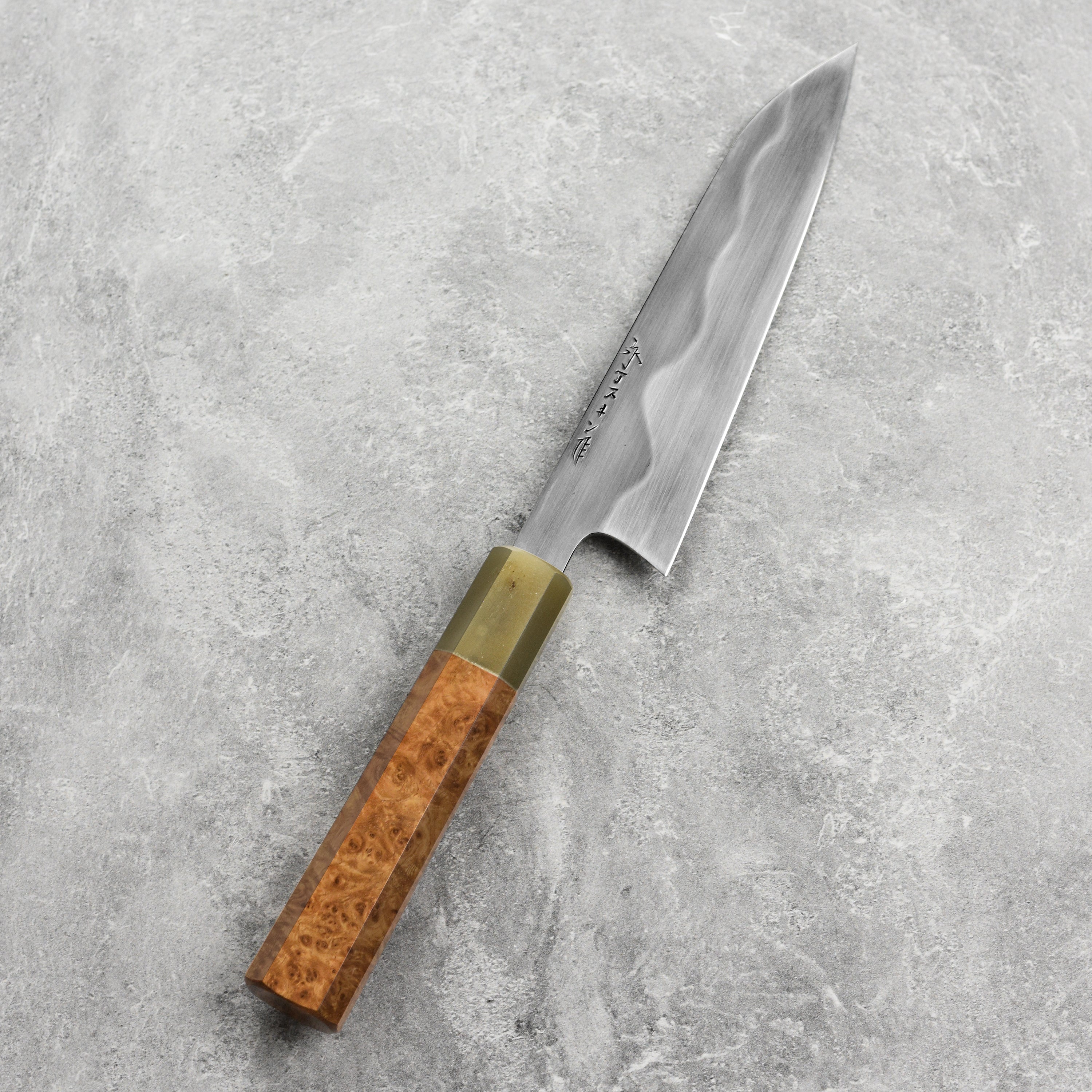 Hand-forged carbon steel petty knife with saya, showcasing sharp blade and ergonomic handle.