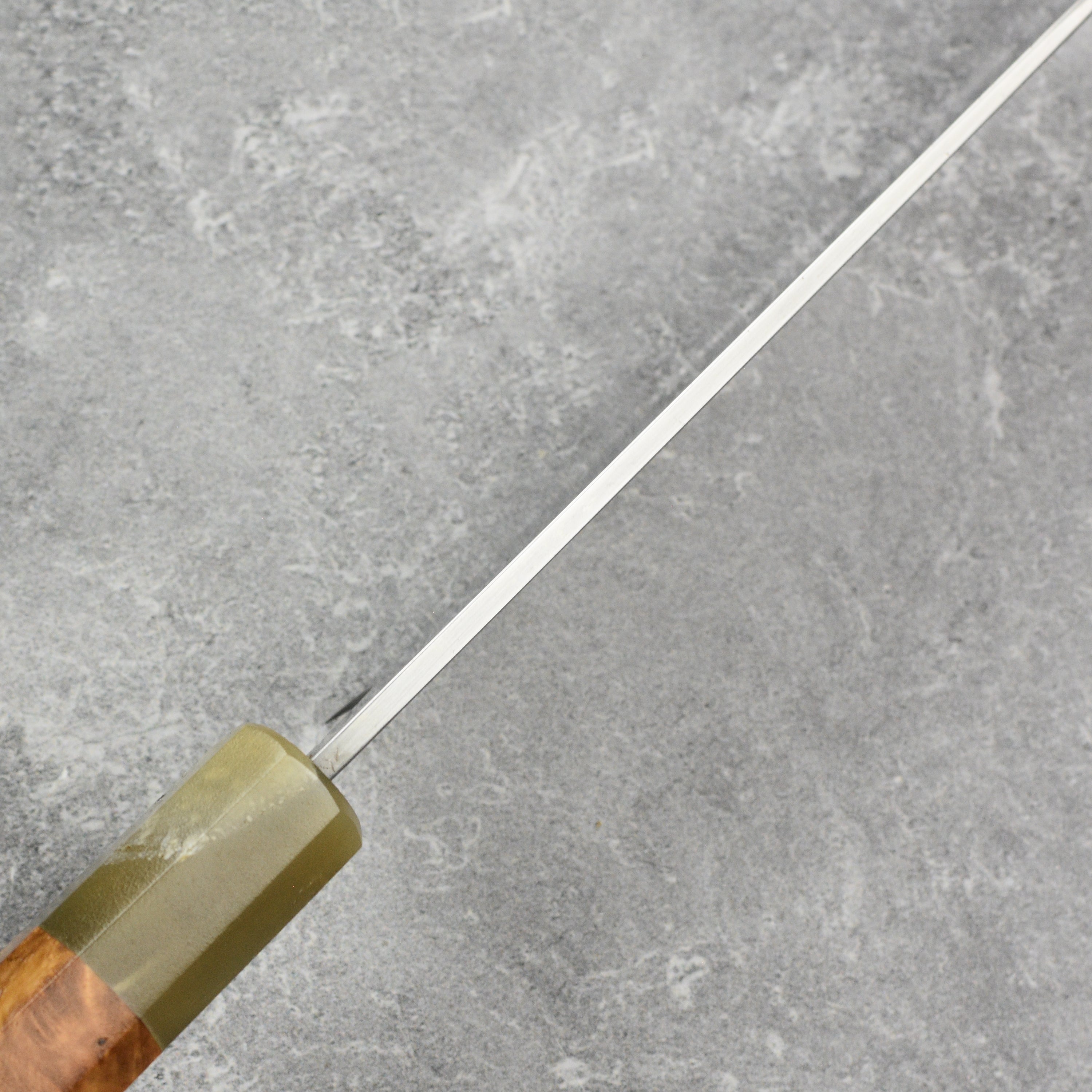 Affordable carbon steel utility knife displayed with its protective saya, emphasizing craftsmanship.
