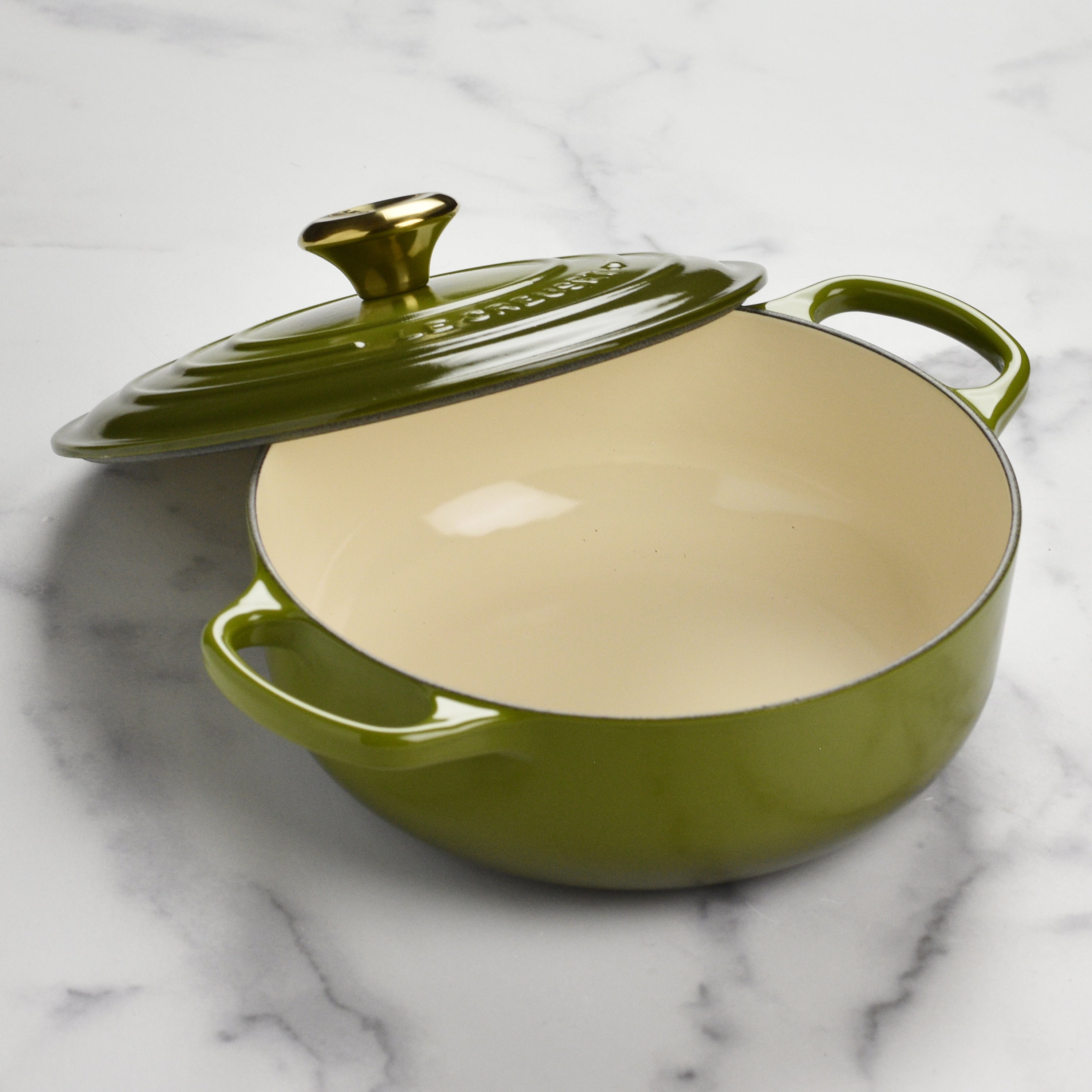 Le Creuset sauteuse on a stove, demonstrating compatibility with various cooktops