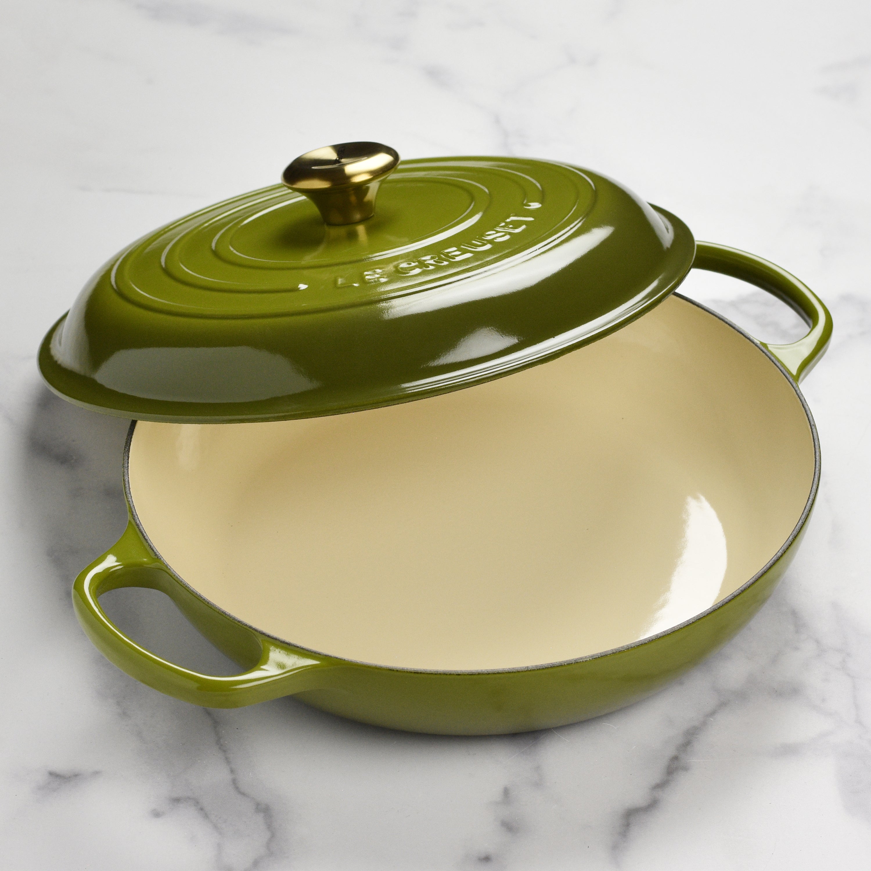 Close-up of the ergonomic handle and gold-finish stainless steel knob on the Le Creuset olive braiser