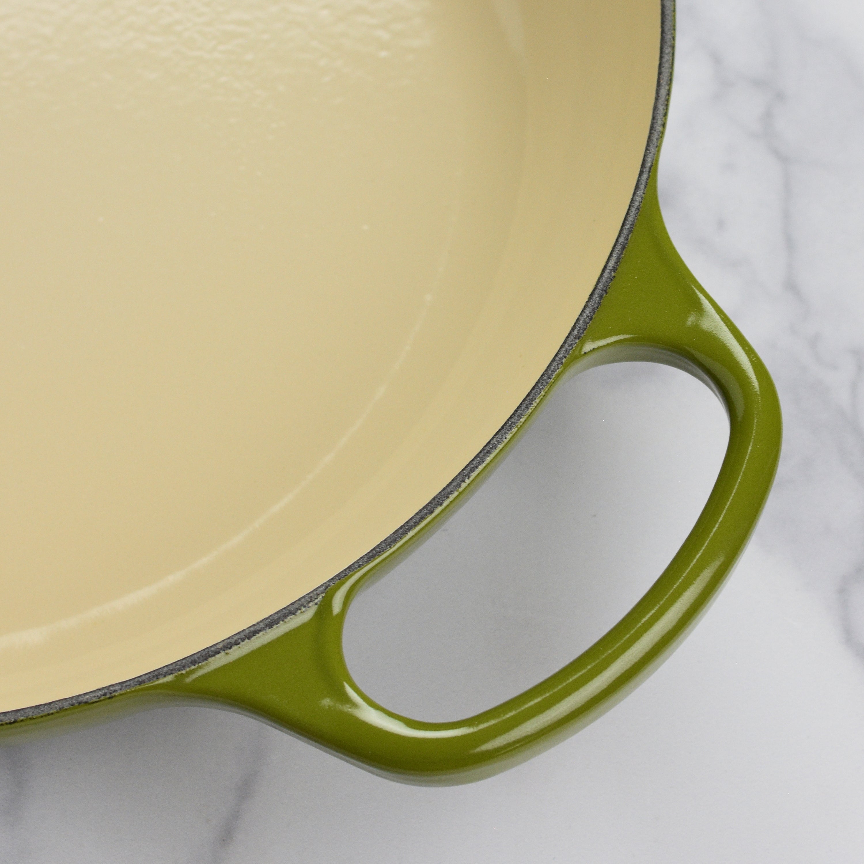 Le Creuset signature cast iron braiser with lid on a stovetop, showcasing its durable enameled surface