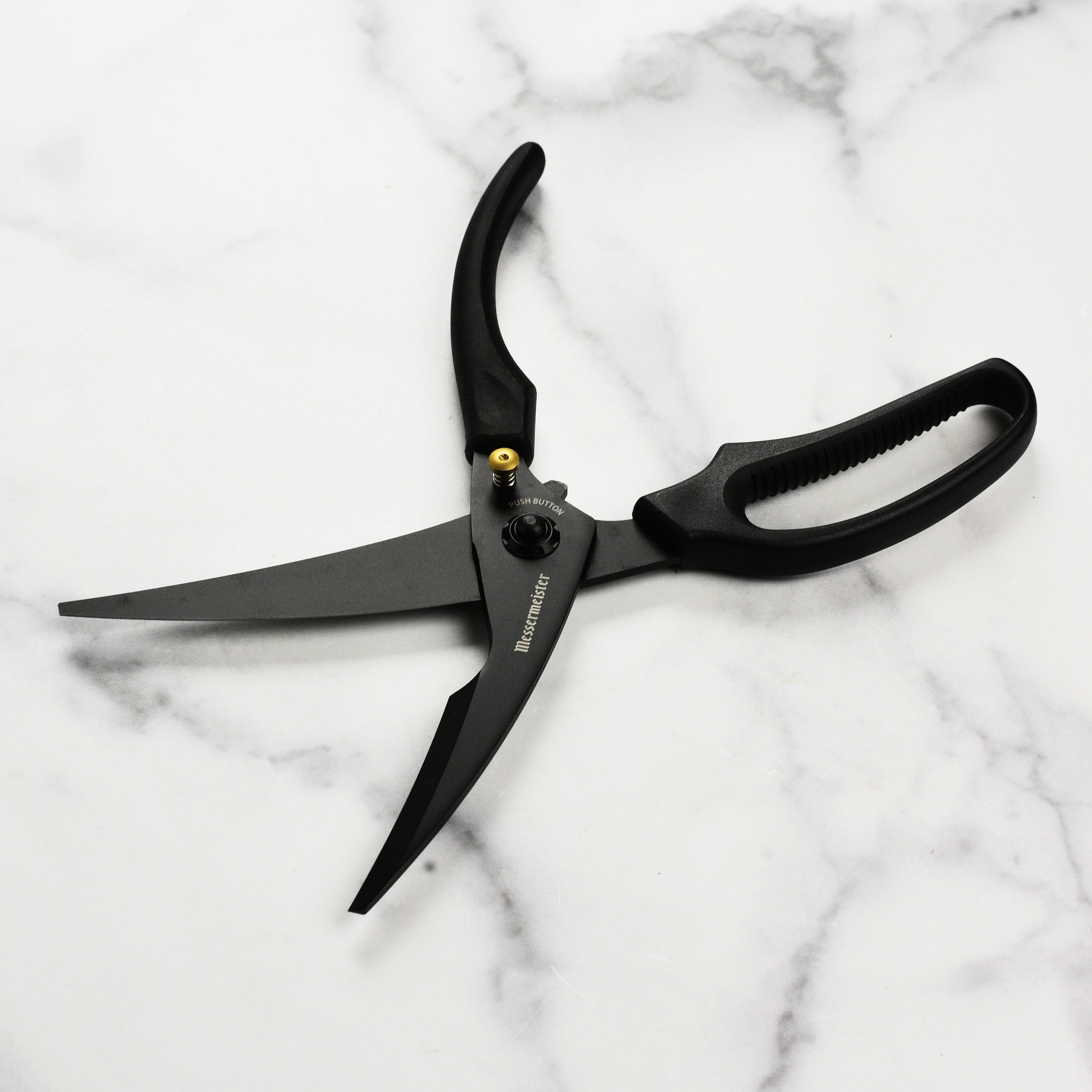 Close-up of the Titanium Pro Poultry Shears demonstrating the push button release feature.