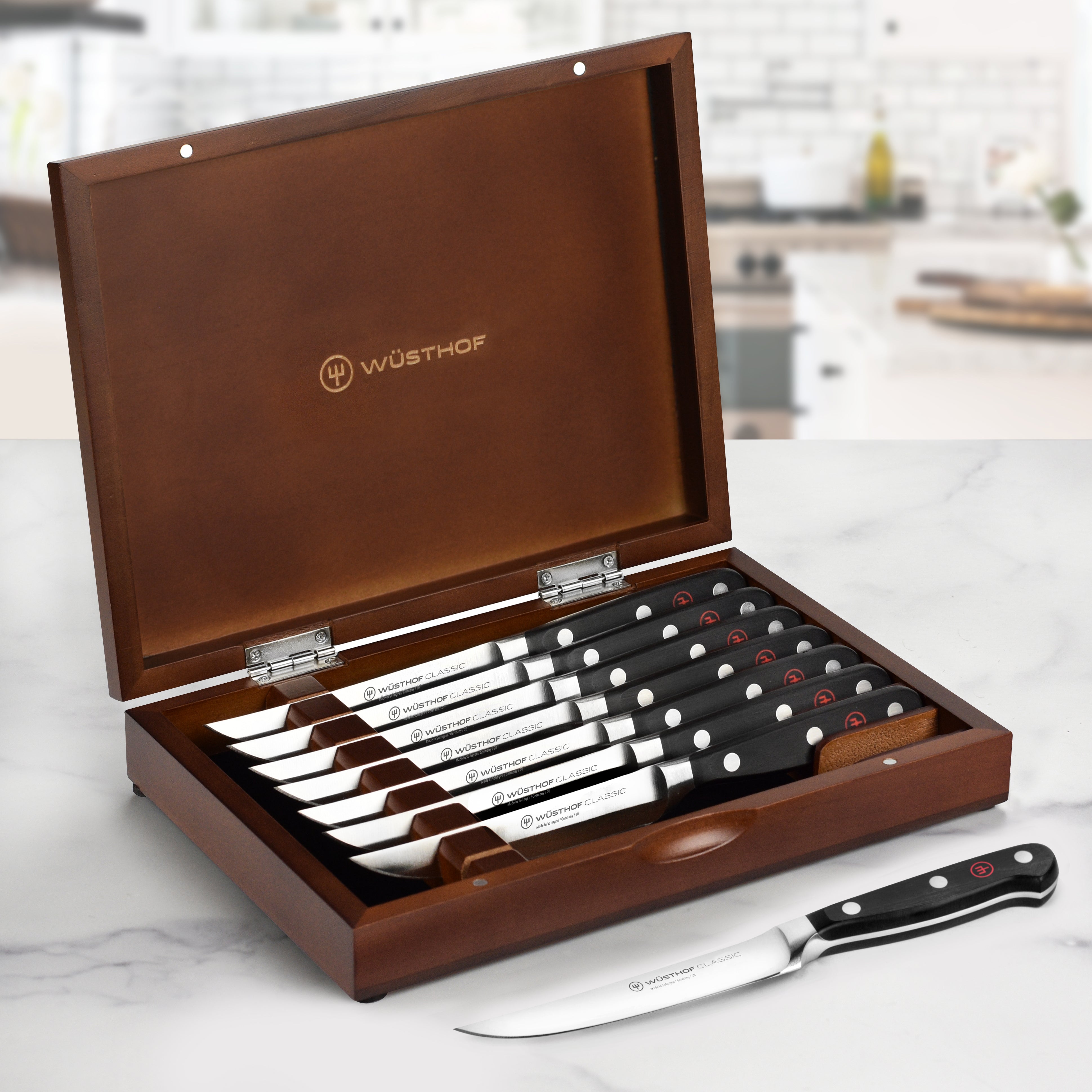 Close-up view of Wusthof premium steak knives with polished blades and elegant wood case.