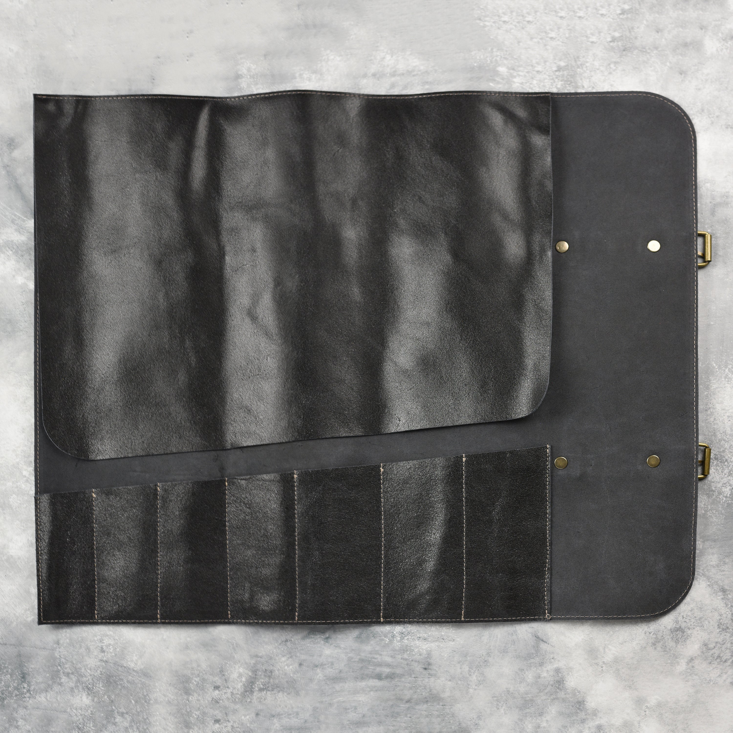 Chef using the vintage leather knife roll in a professional kitchen, demonstrating its practicality.
