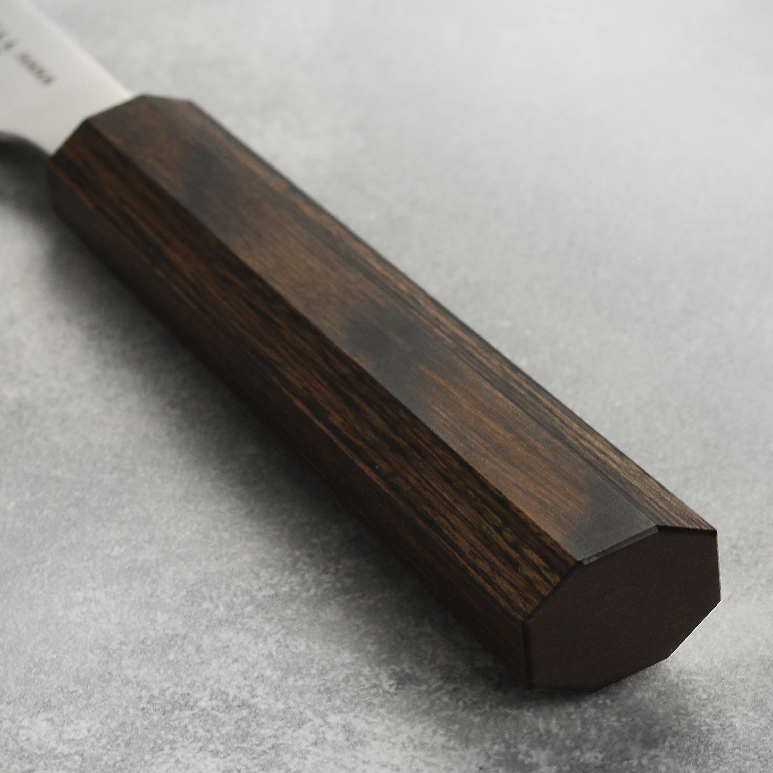 Close-up of Yaxell Hana petty knifes ergonomic handle, designed for comfort and control during use.