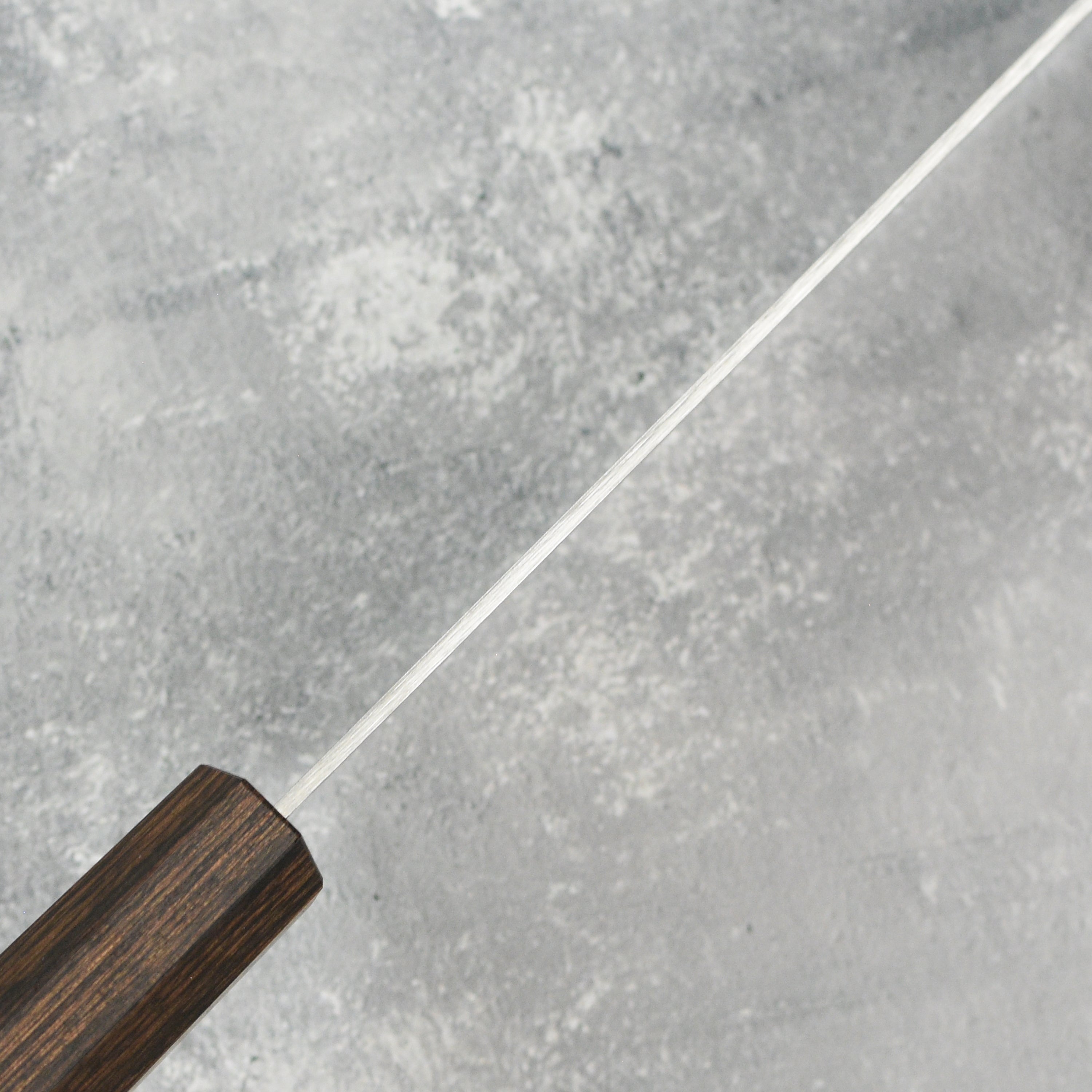 Yaxell Hana petty knife displayed with fresh vegetables, demonstrating precision cutting capabilities.