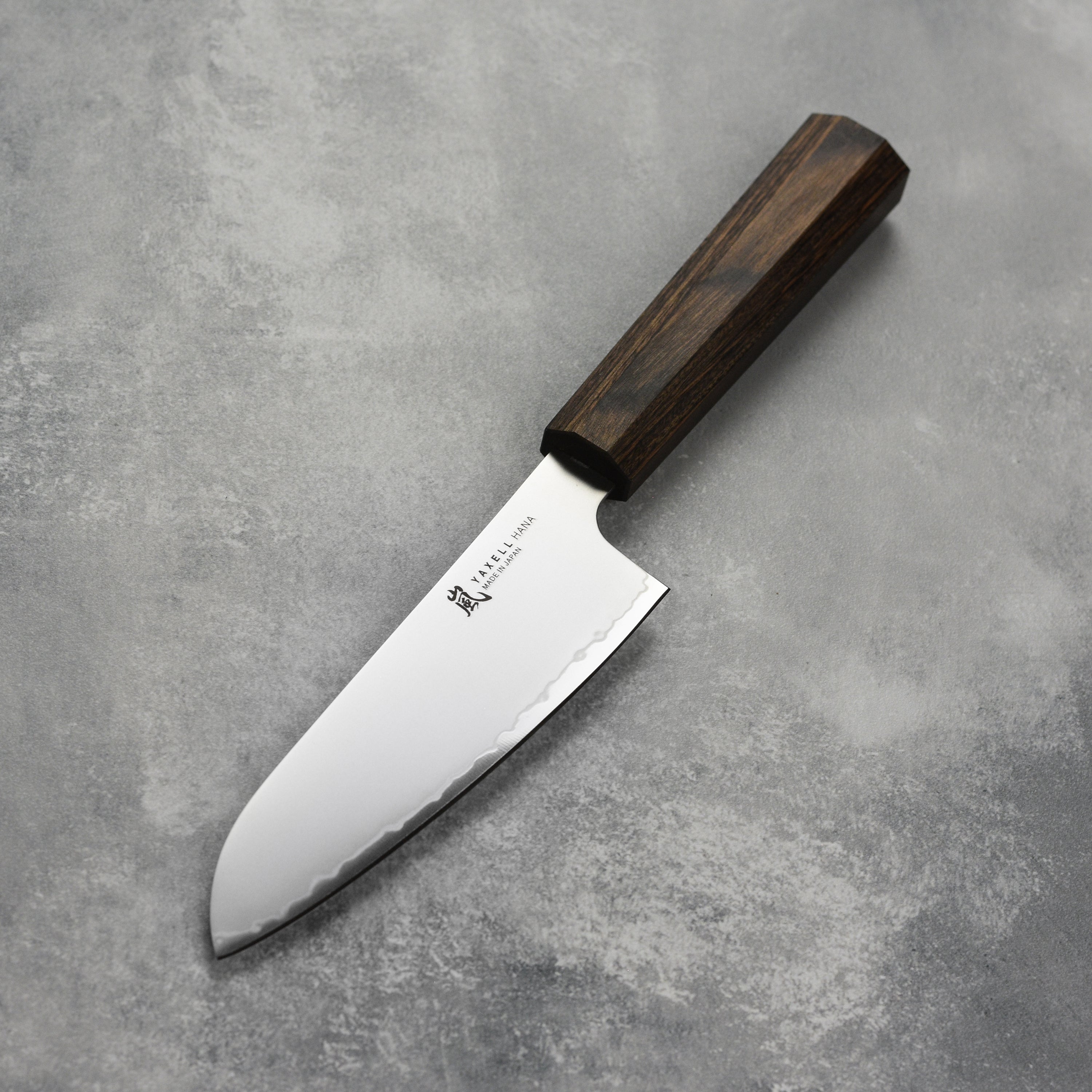 Yaxell Hana Santoku knife in use, demonstrating its precision and control in food preparation.
