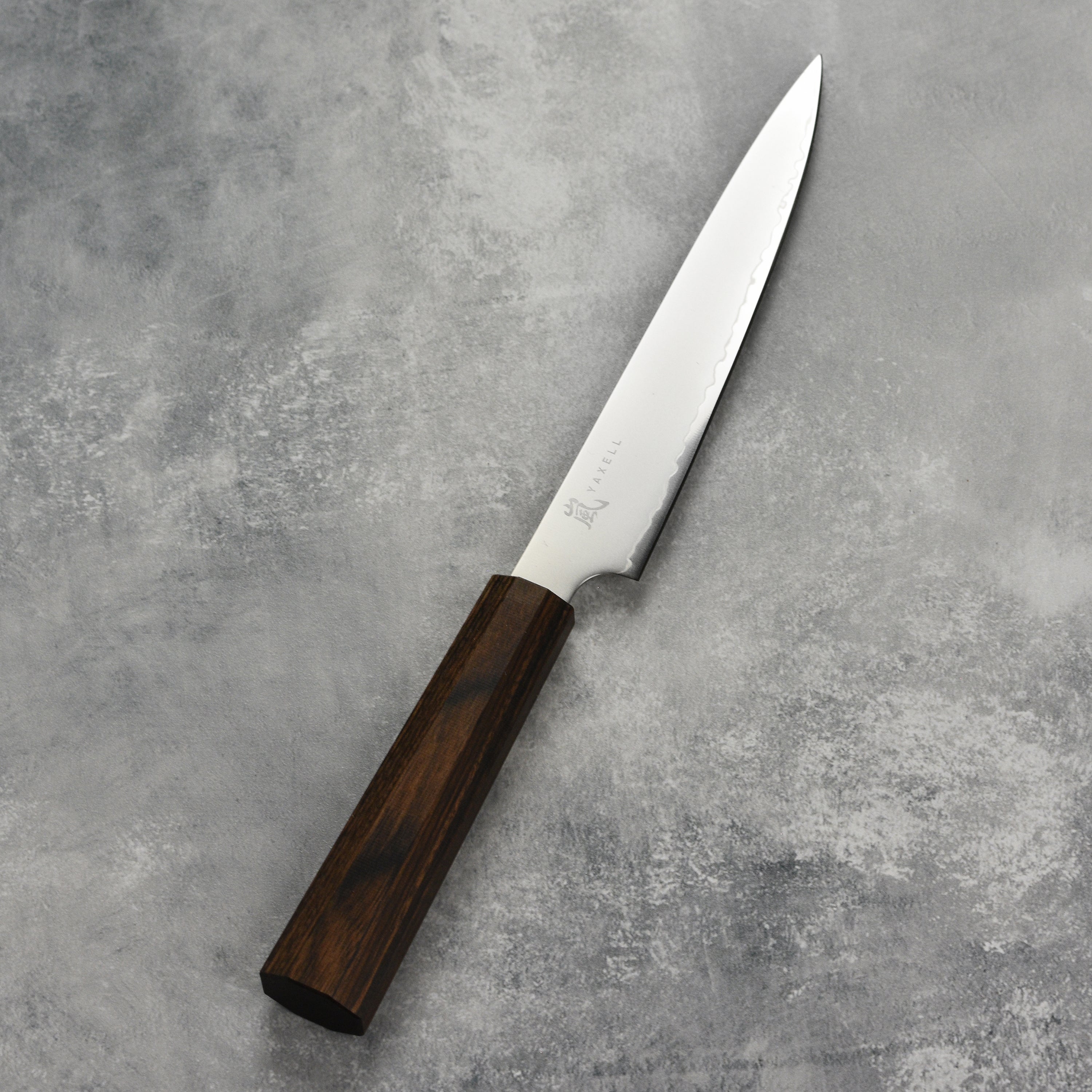 Yaxell Hana 6-inch Japanese utility knife with pakkawood handle on cutting board