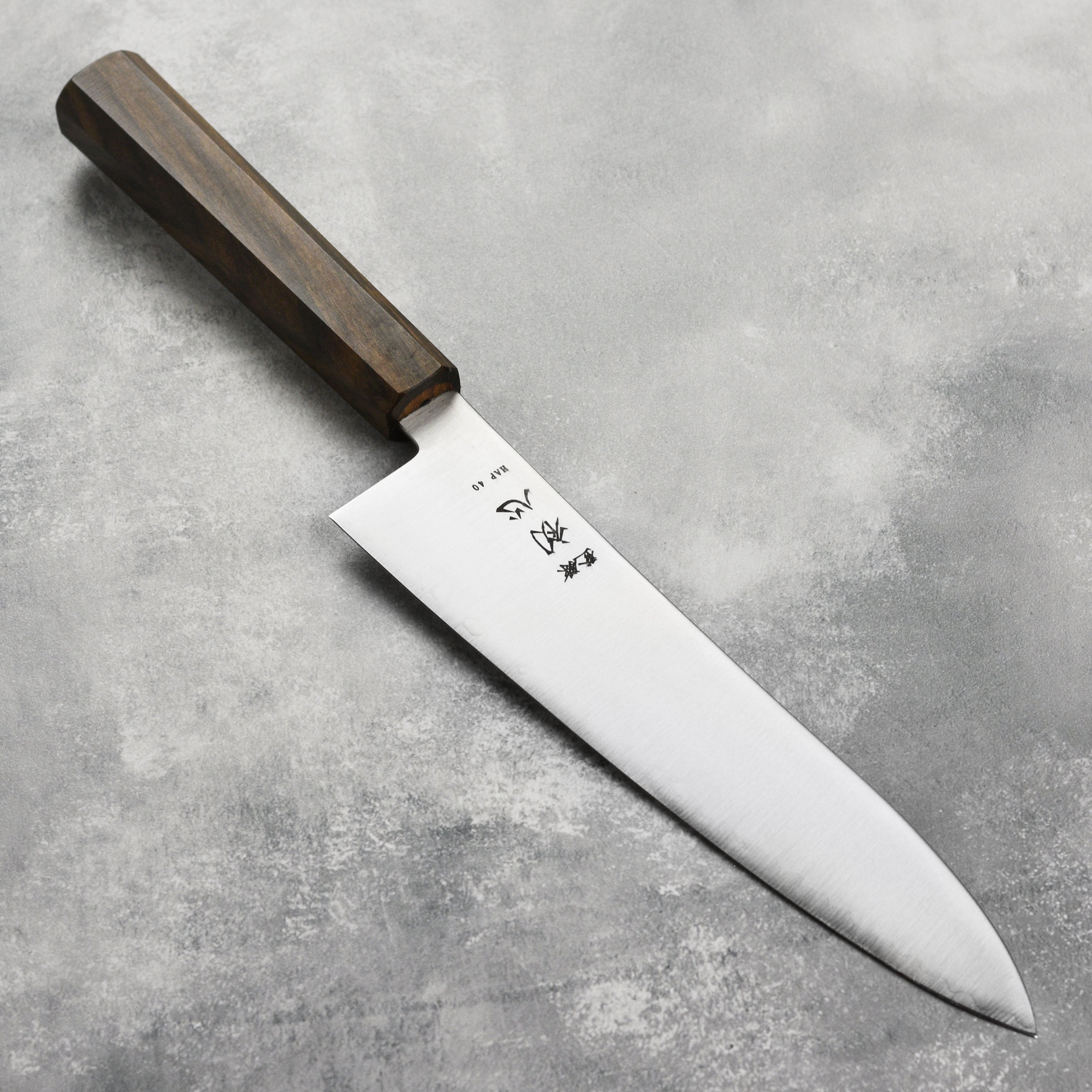 Hatsukokoro Hayabusa HAP40 Gyuto knife on a cutting board, ideal for professional chefs.