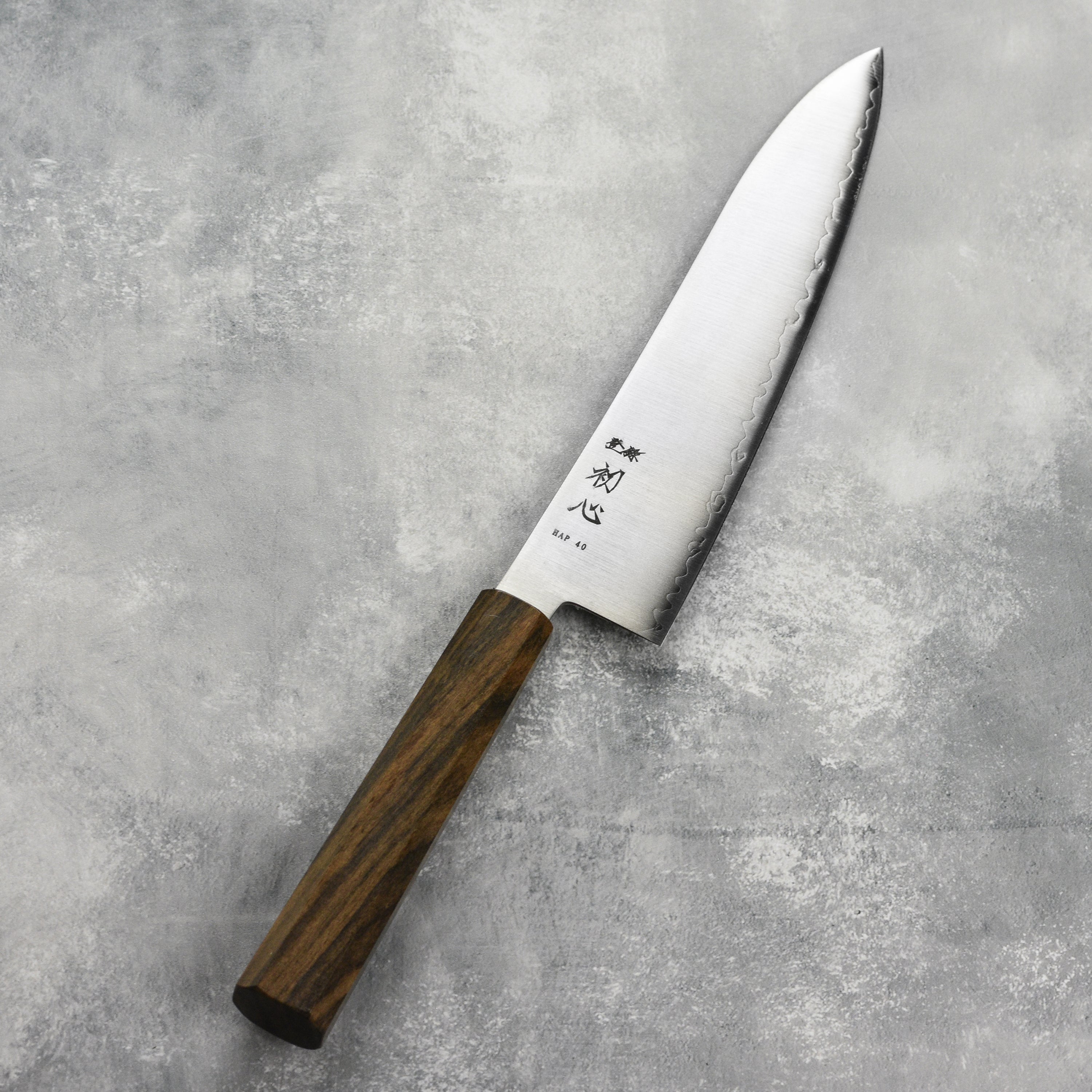 Hatsukokoro Hayabusa HAP40 Gyuto knife on a cutting board, ideal for professional chefs.