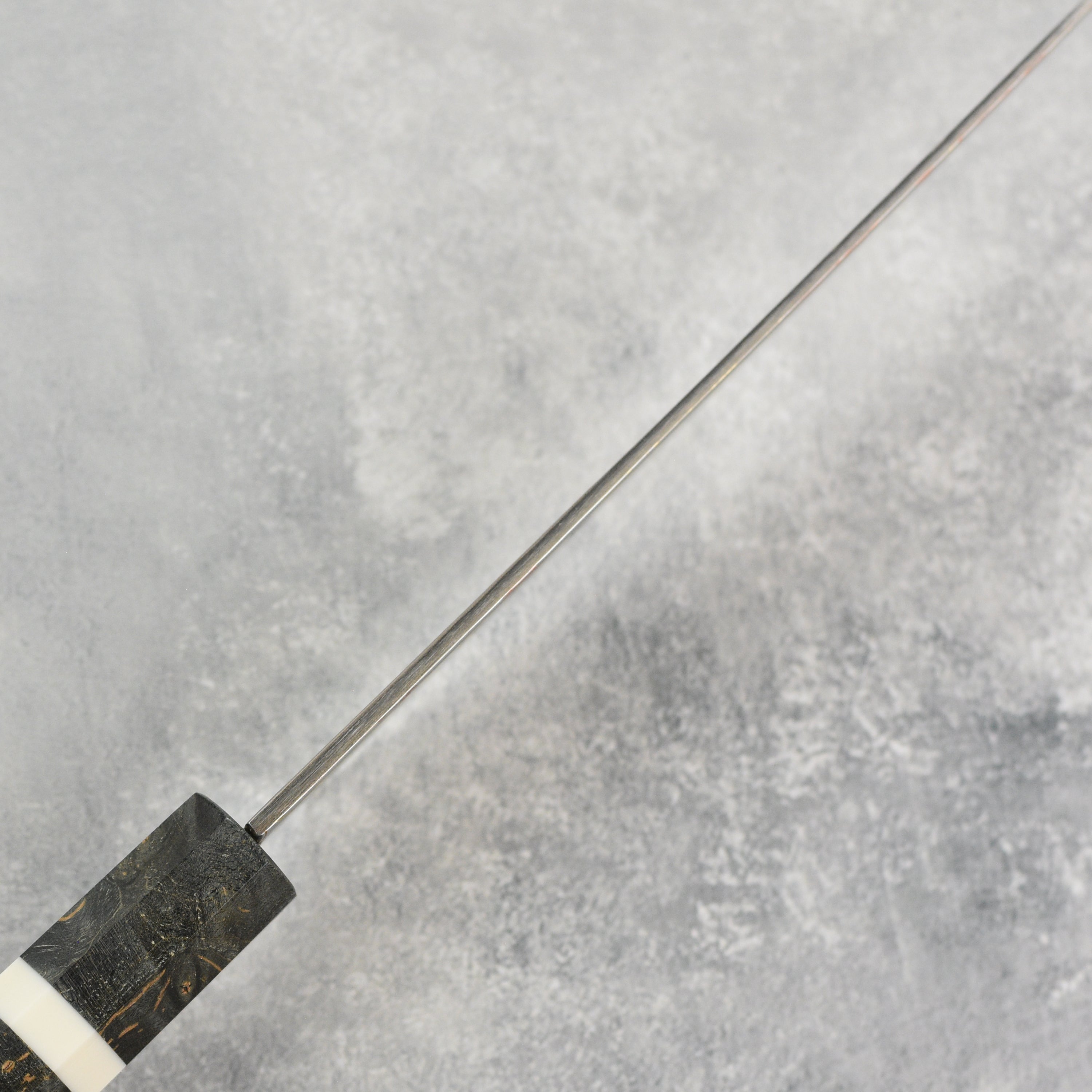 Display of the Hatsukokoro Hayabusa Aogami Rainbow Damascus Chef Knife with its elegant packaging.
