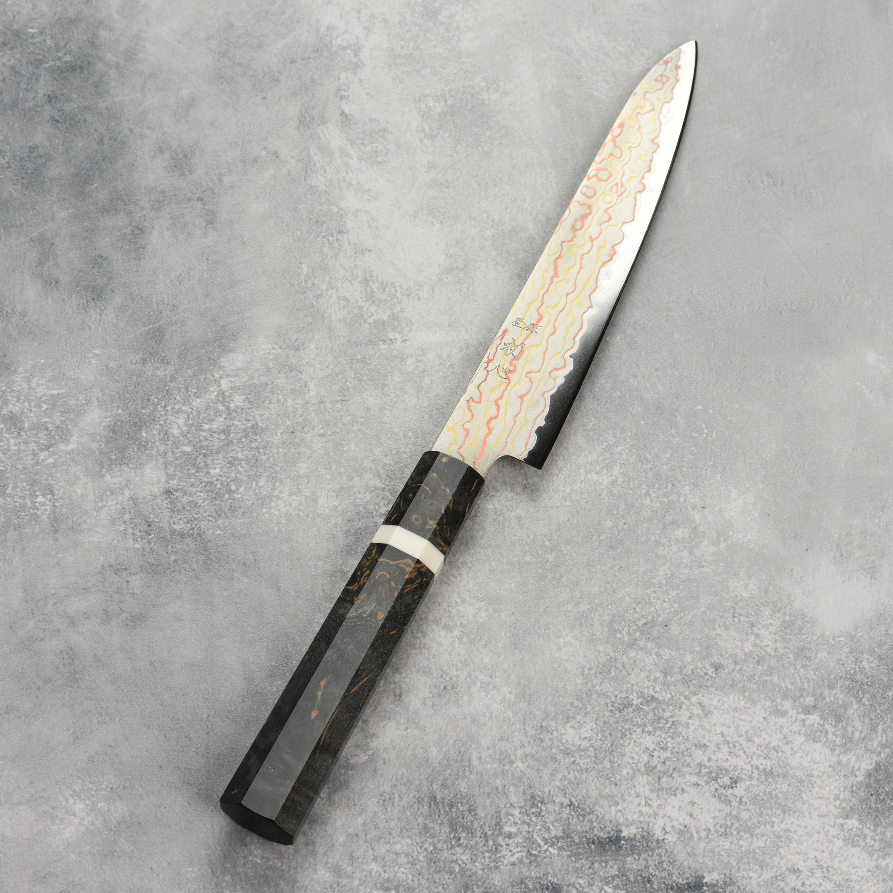 Hatsukokoro Hayabusa Aogami knife in action, slicing fresh vegetables on a wooden cutting board.