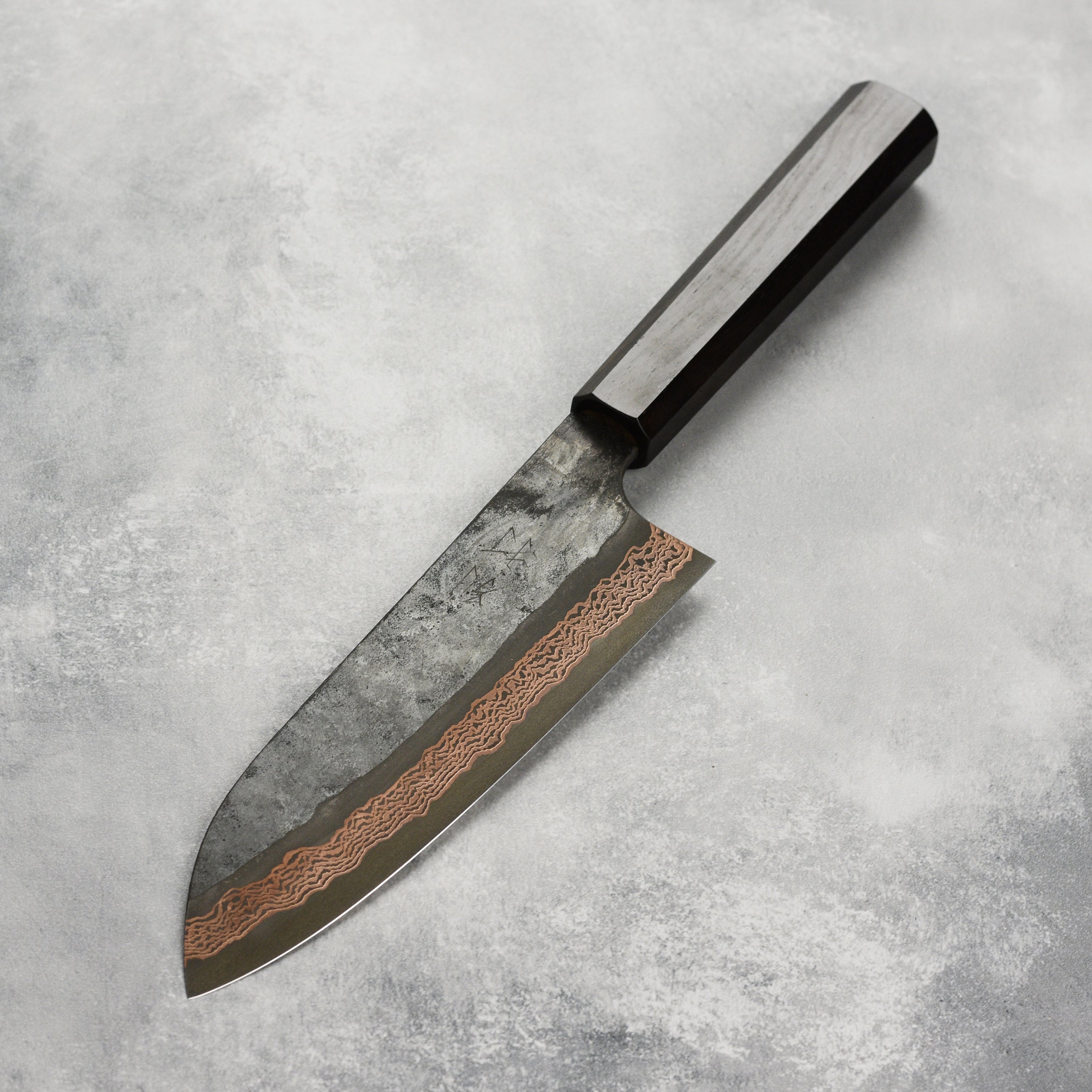 Hatsukokoro Santoku Knife in use, expertly slicing vegetables to demonstrate its precision and balance.