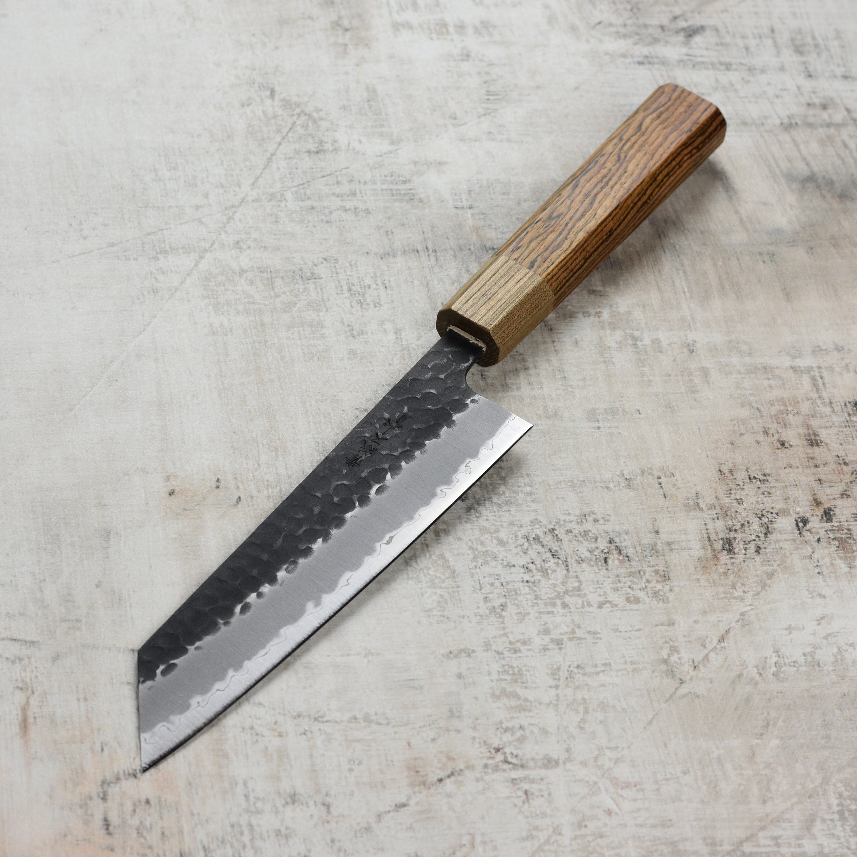 Close-up of the Ittetsu Aogami Bunka knife, displaying the high carbon steel blade and Kurouchi finish.