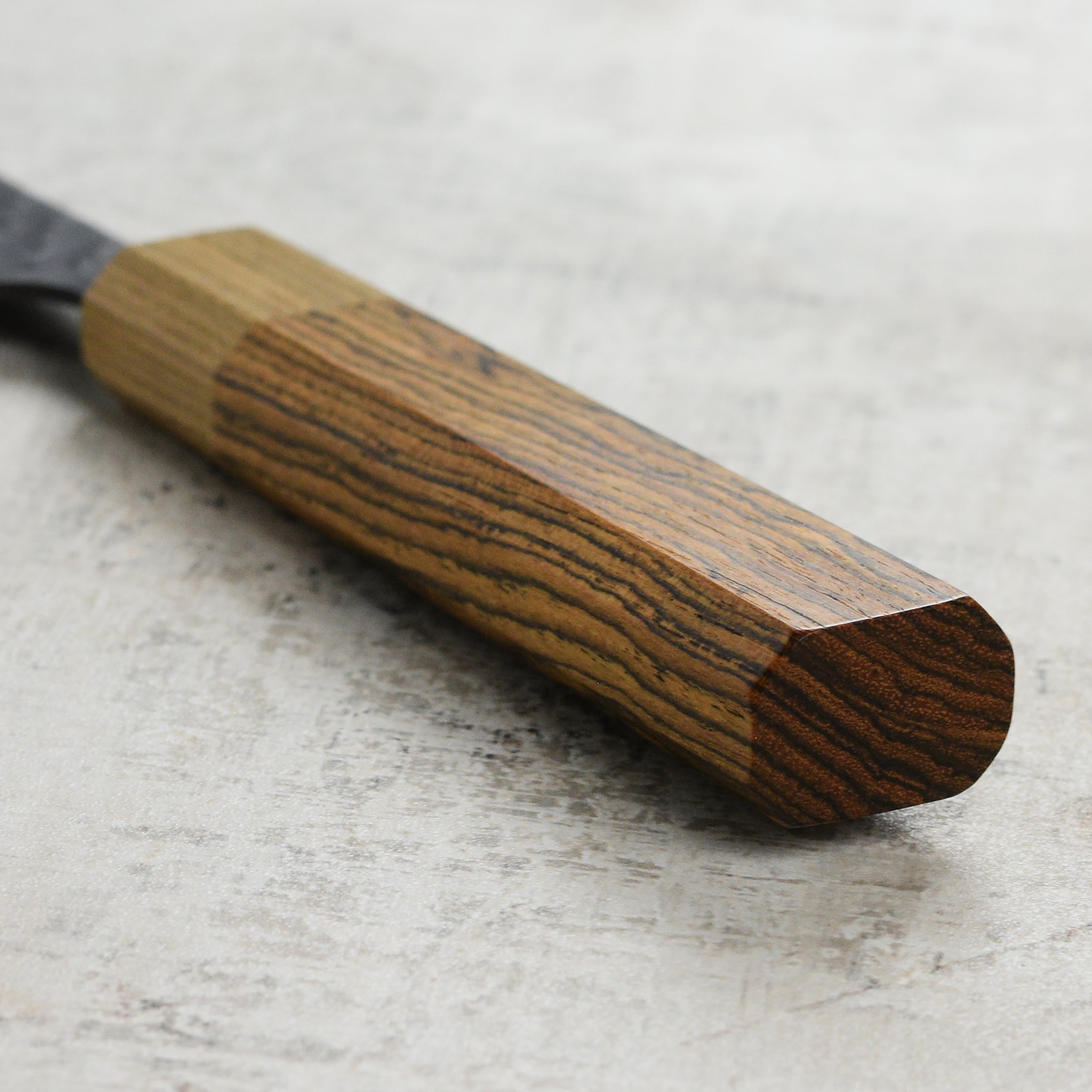 Close-up of the Ittetsu Aogami Bunka knife, displaying the high carbon steel blade and Kurouchi finish.