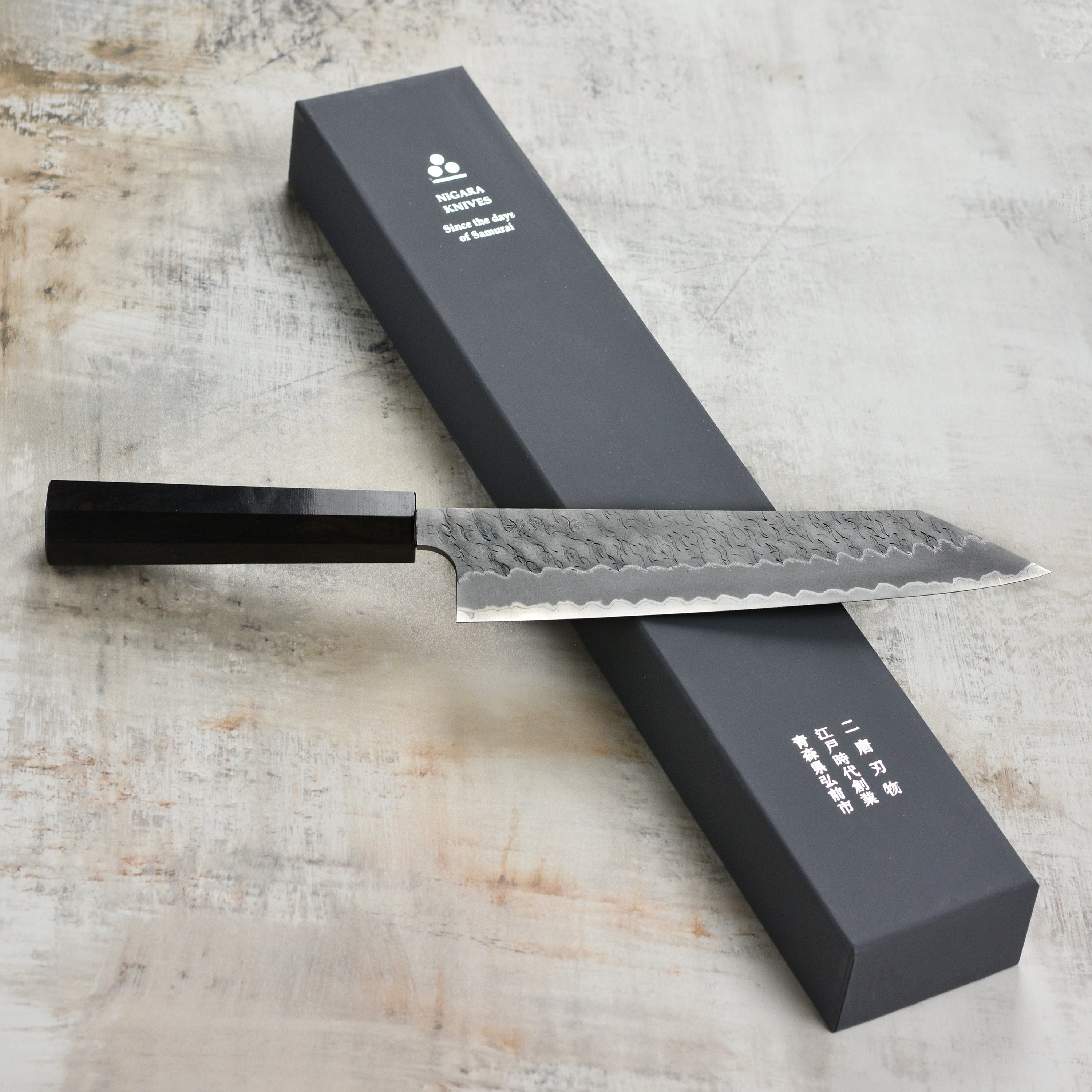 Premium Aogami Super Migaki Tsuchime 9.4" Kiritsuke Chef Knife in action, slicing vegetables.