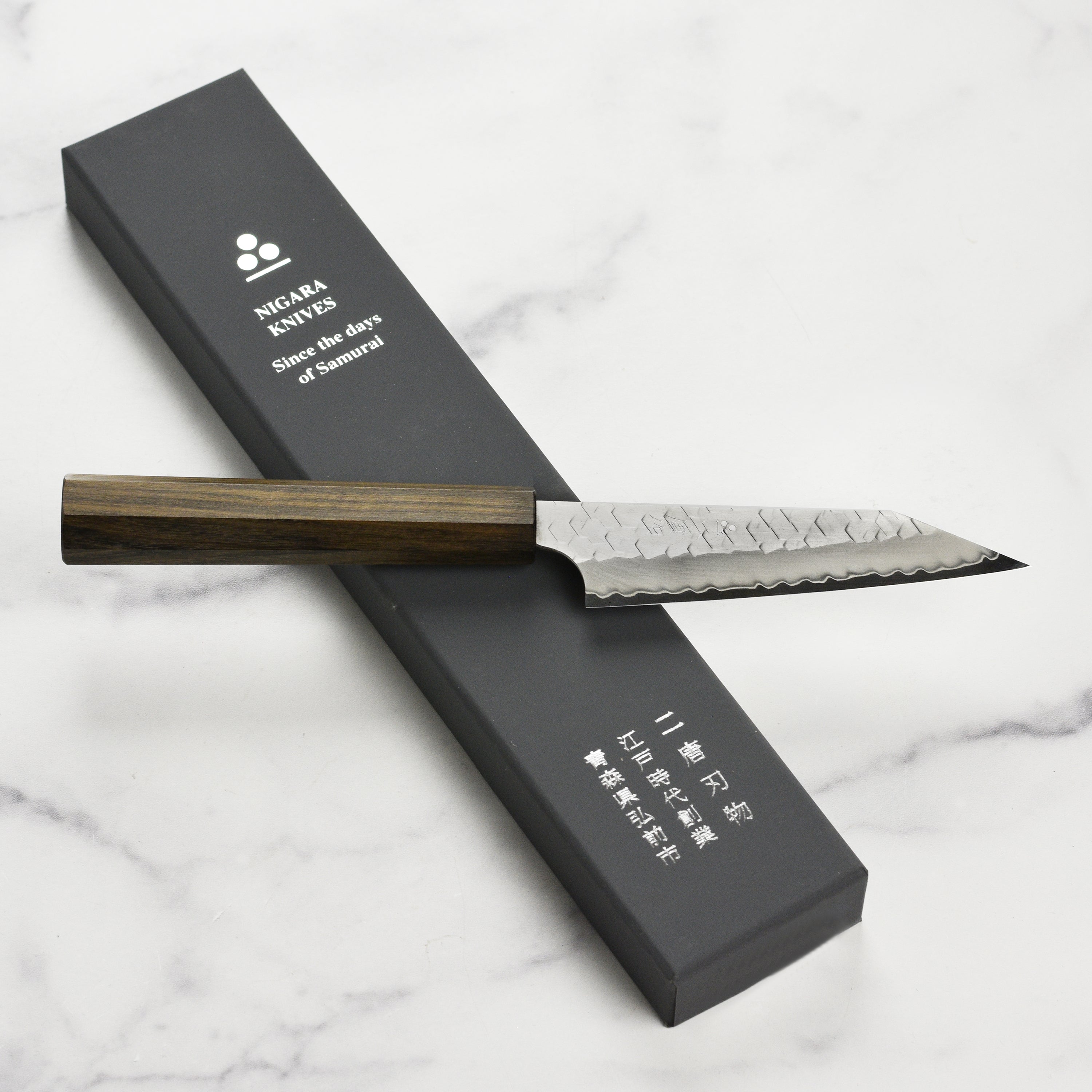 Close-up of the Nigara SG2 Kiritsuke petty knife cutting fresh herbs, demonstrating precision and sharpness.