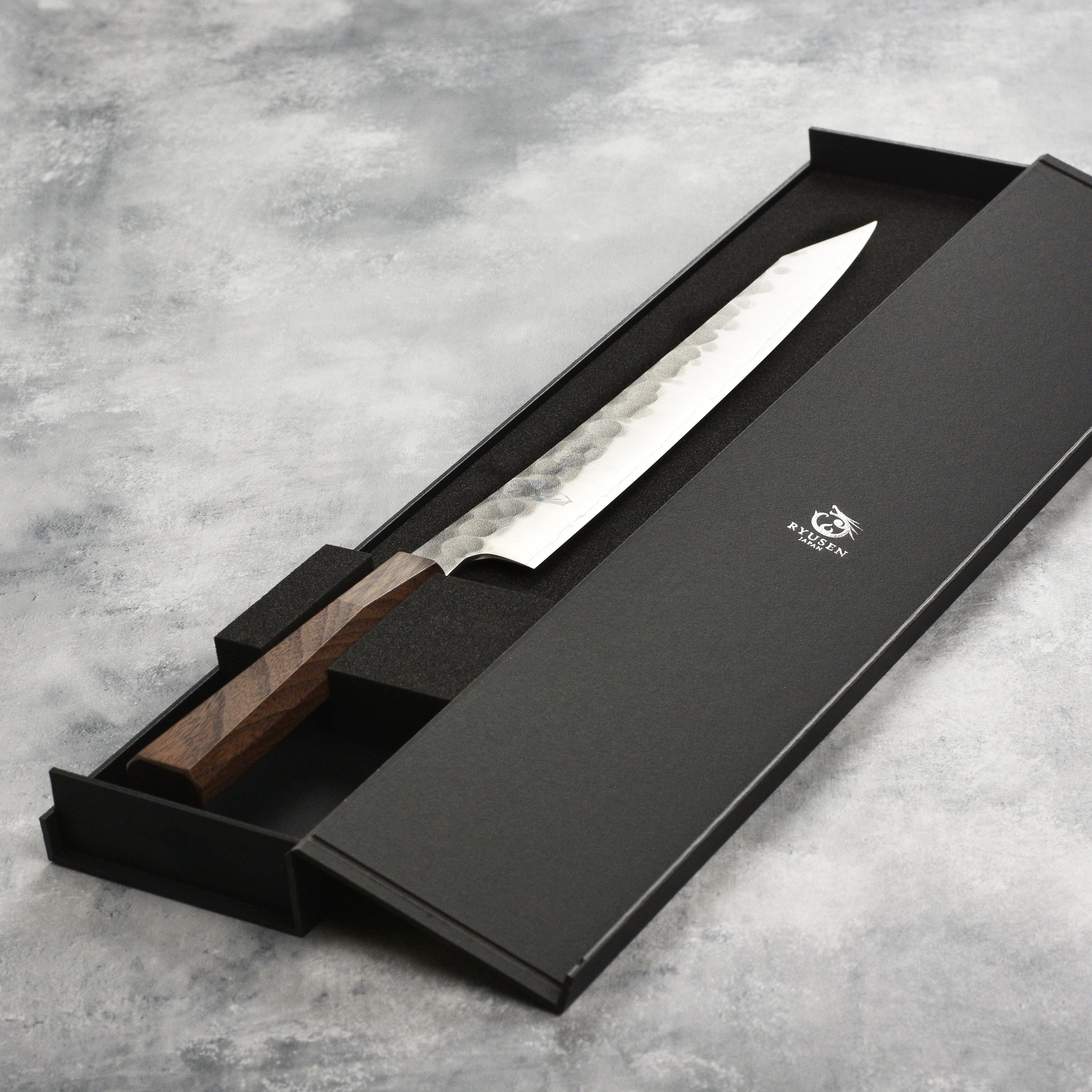 Sushi chef using the Ryusen Blazen Ryu Wa SG2 10.25" Japanese slicing knife for precise fish cuts