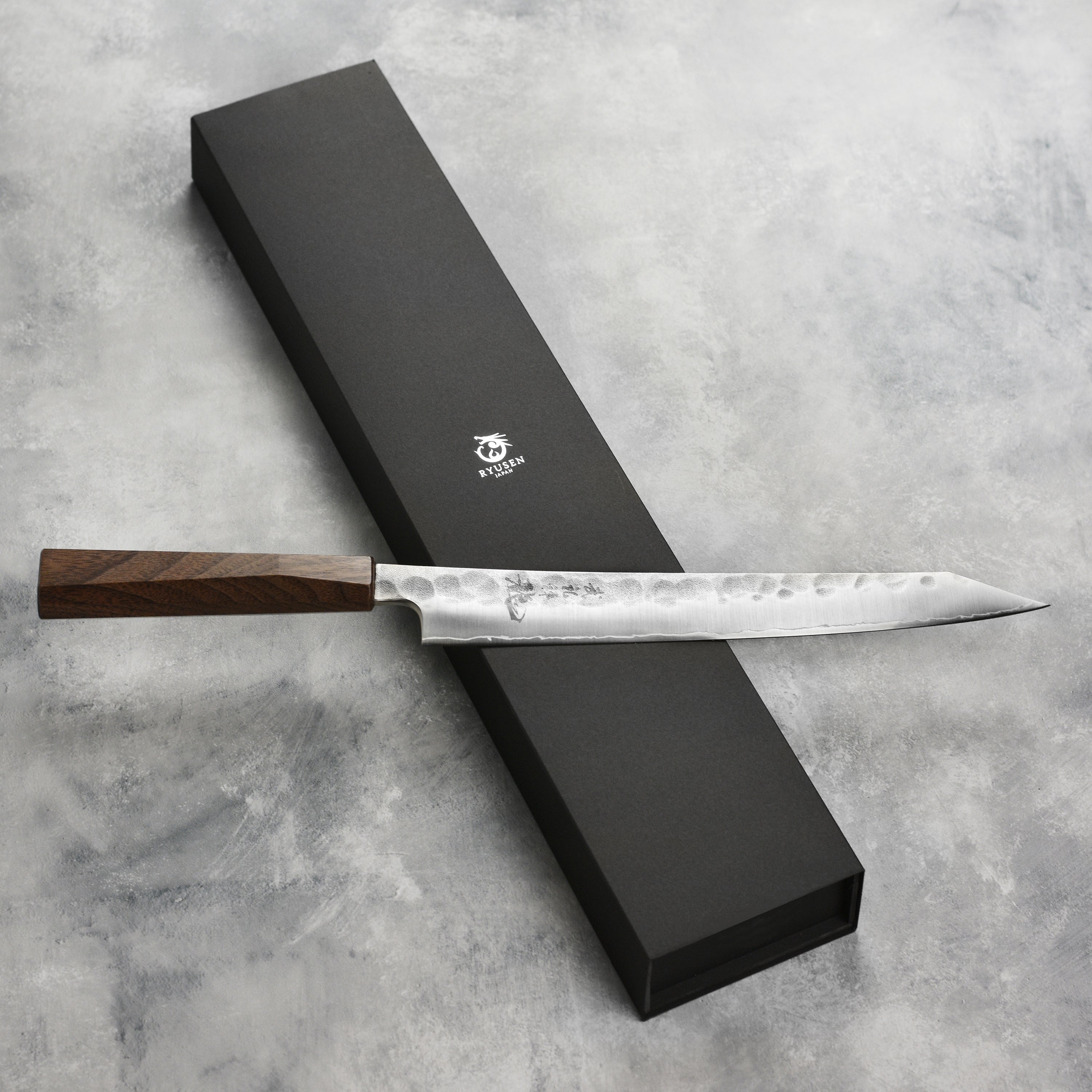 Sushi chef using the Ryusen Blazen Ryu Wa SG2 10.25" Japanese slicing knife for precise fish cuts