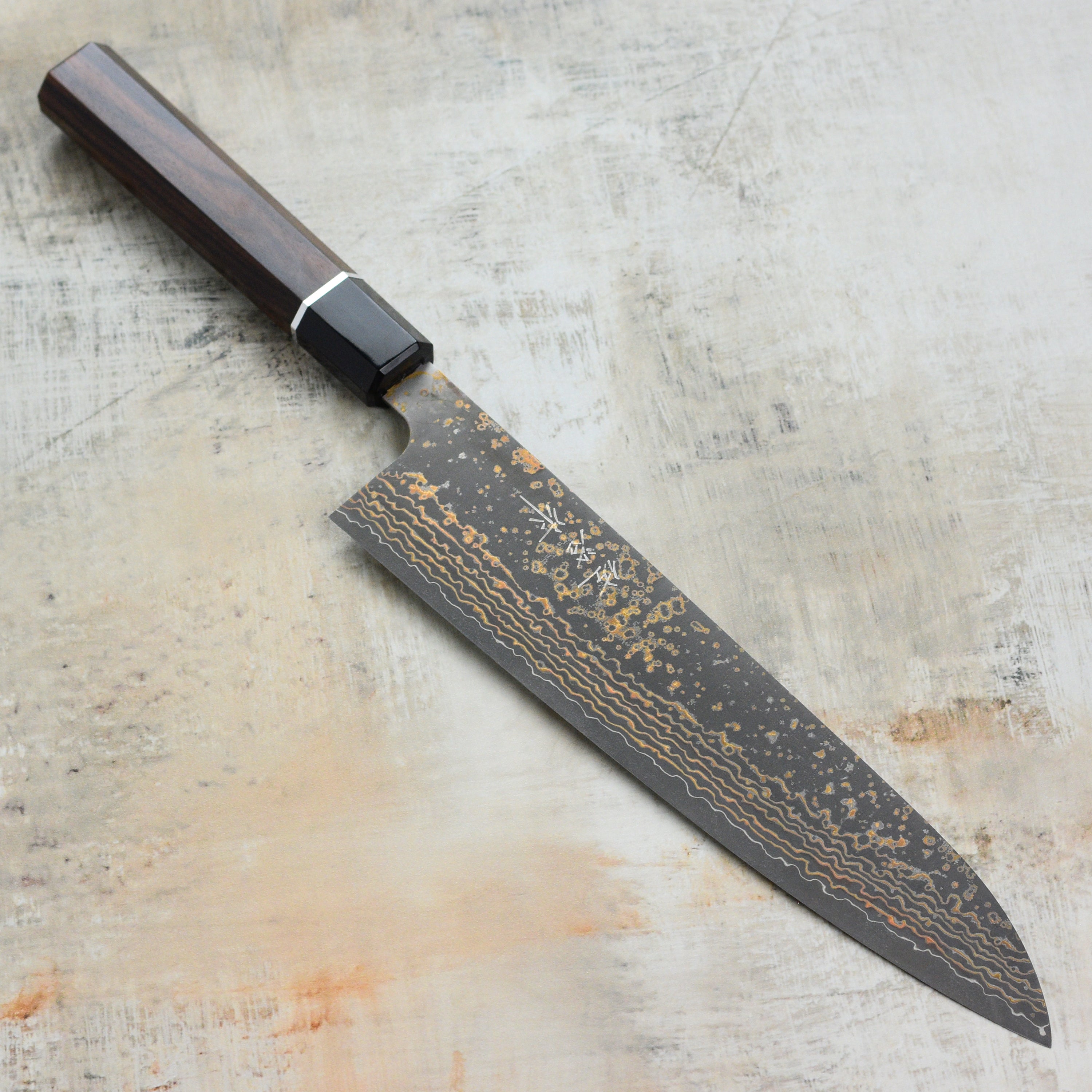 Saji Black Gold Damascus gyuto knife with layered steel blade and gold accents