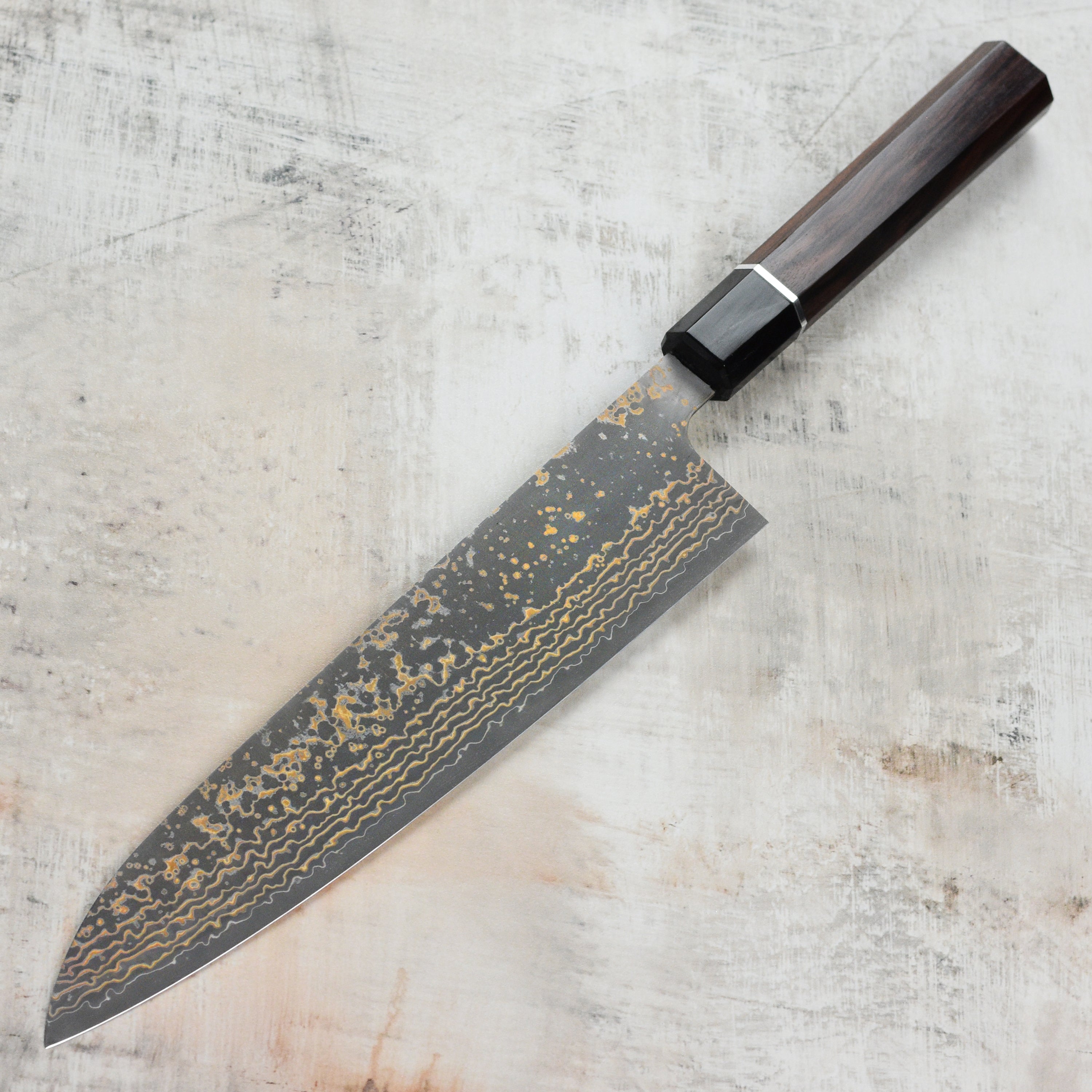 Chef slicing vegetables with the Saji Black Gold Damascus kitchen knife