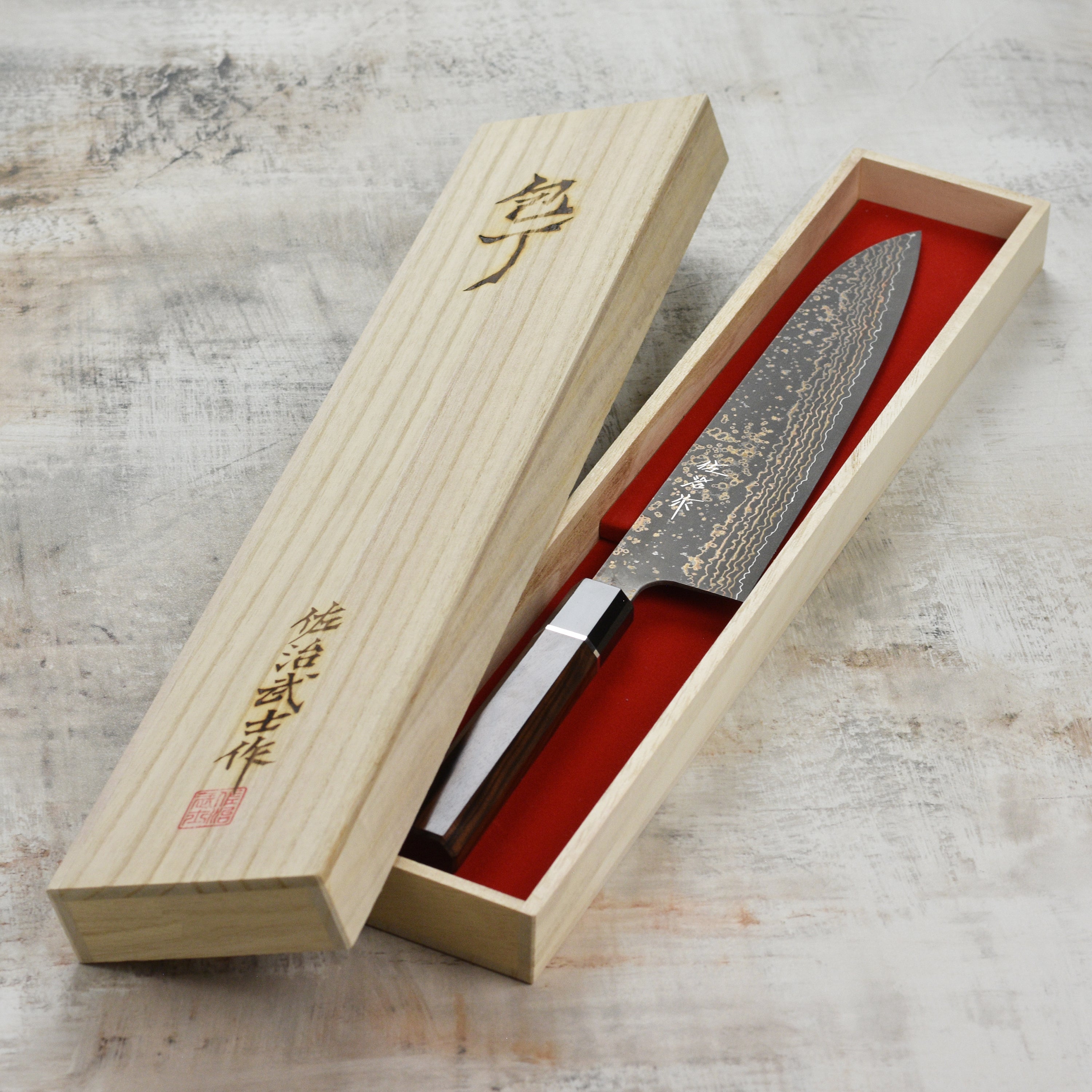 Saji Black Gold Damascus gyuto knife with layered steel blade and gold accents
