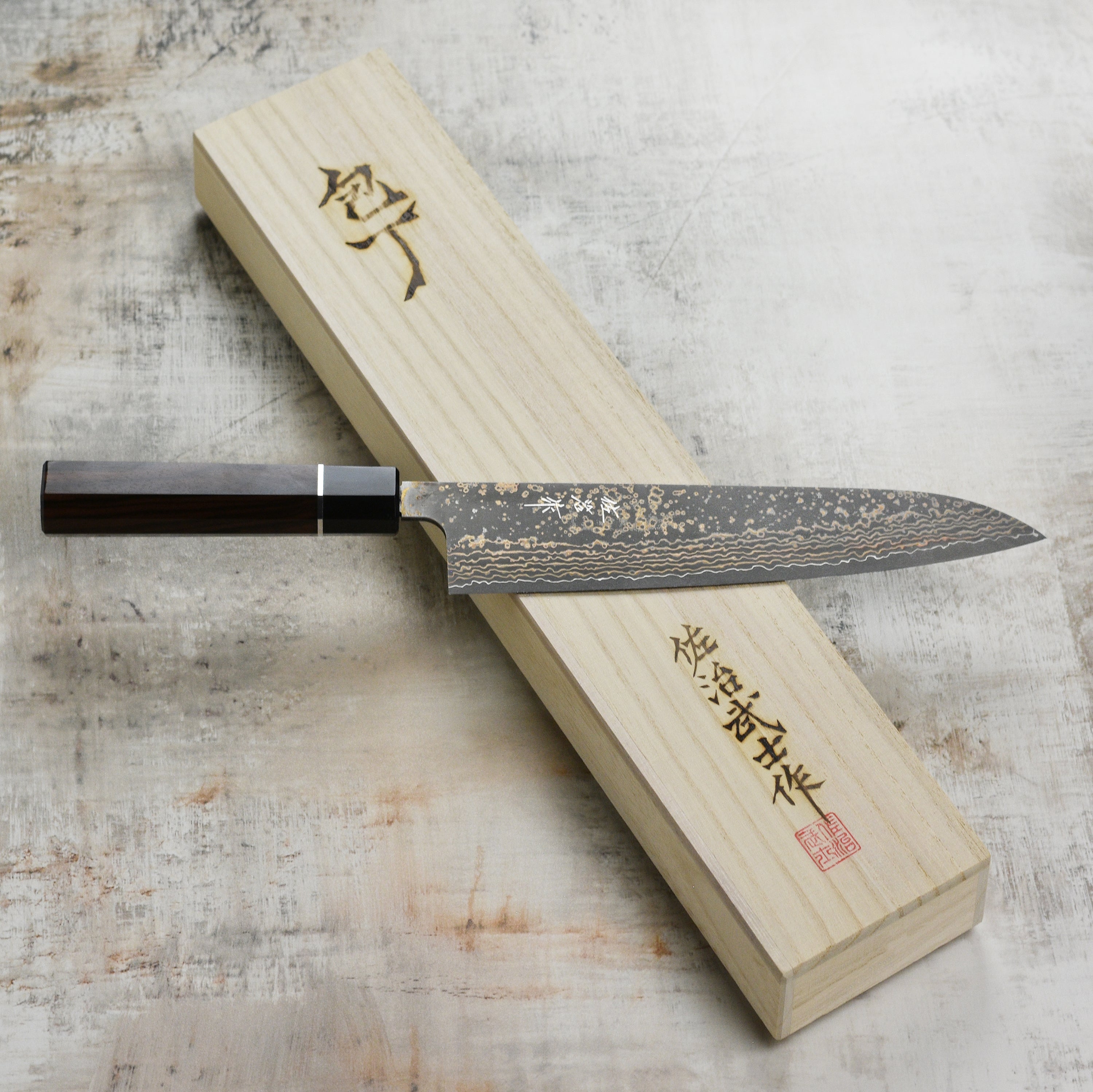 Saji Black Gold Damascus gyuto knife with layered steel blade and gold accents