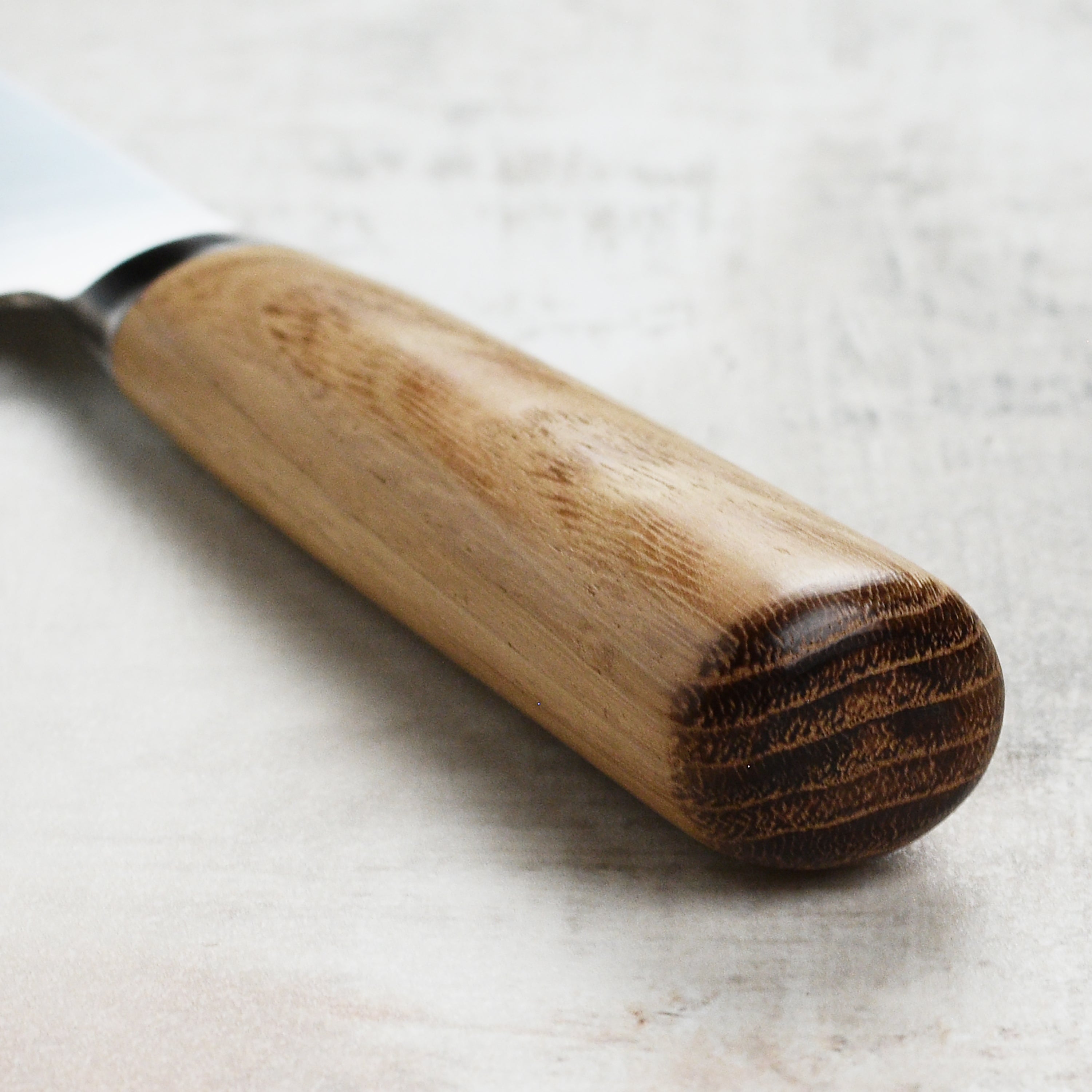 Chef slicing vegetables with the Japanese Santoku knife on a wooden cutting board