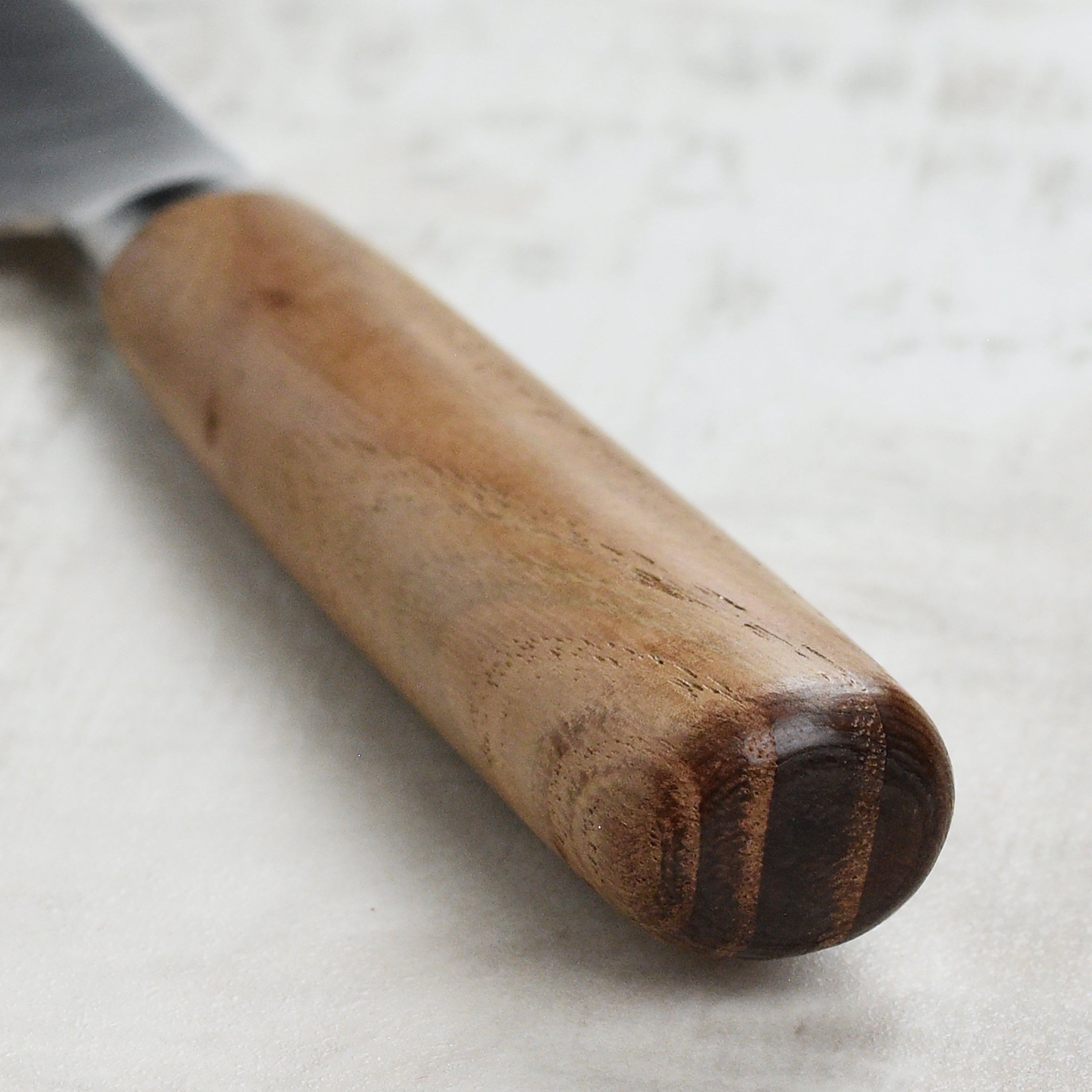 Tadafusa Hocho Kobo petty knife in use, expertly slicing vegetables on a wooden cutting board.