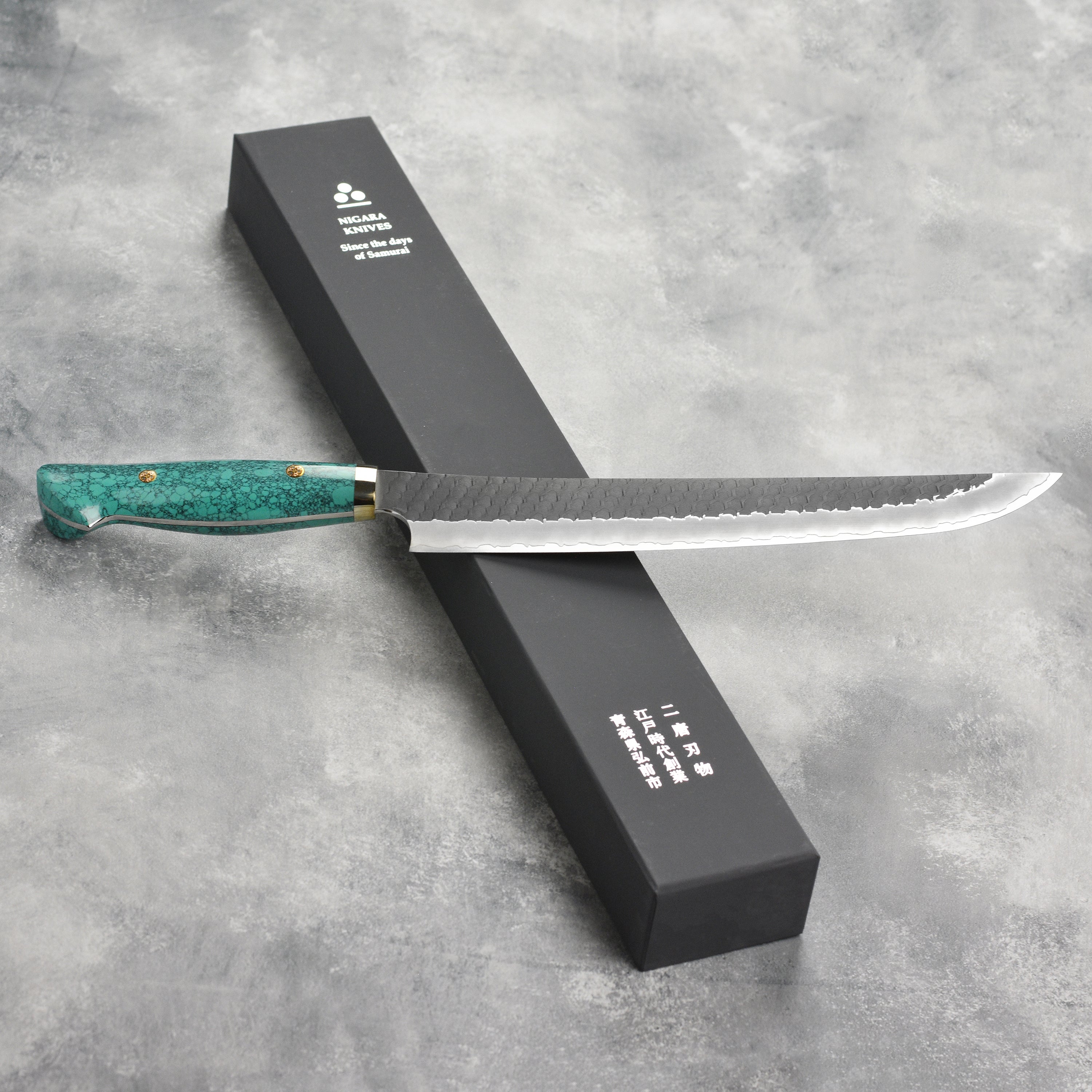 Close-up of Nigara SG2 Kurouchi Sujihiki 10.6 inch blade showcasing its sharp edge for slicing meat.