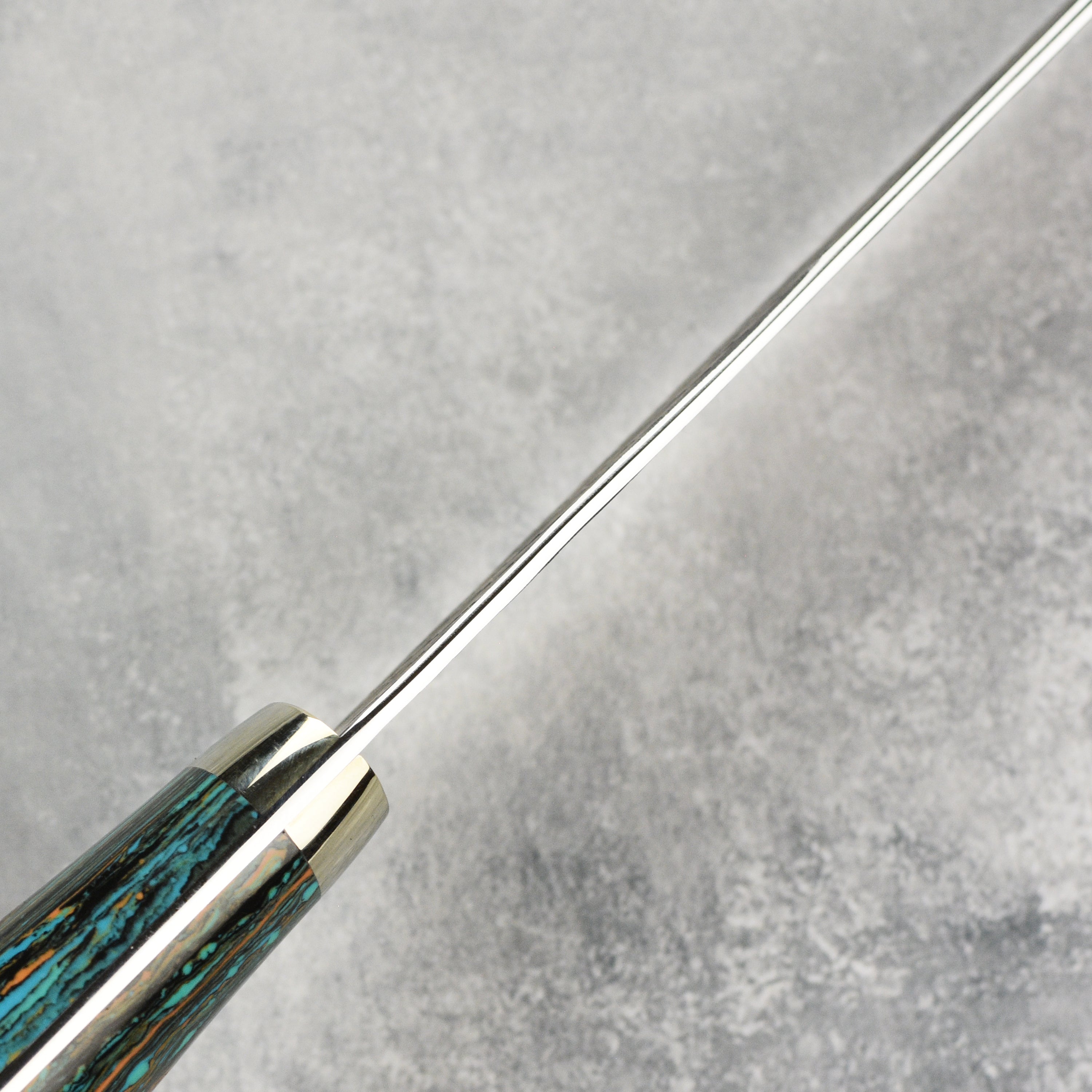 Close-up of Nigara SG2 Kurouchi Tsuchime 10-inch kiritsuke highlighting its textured surface and sharp edge