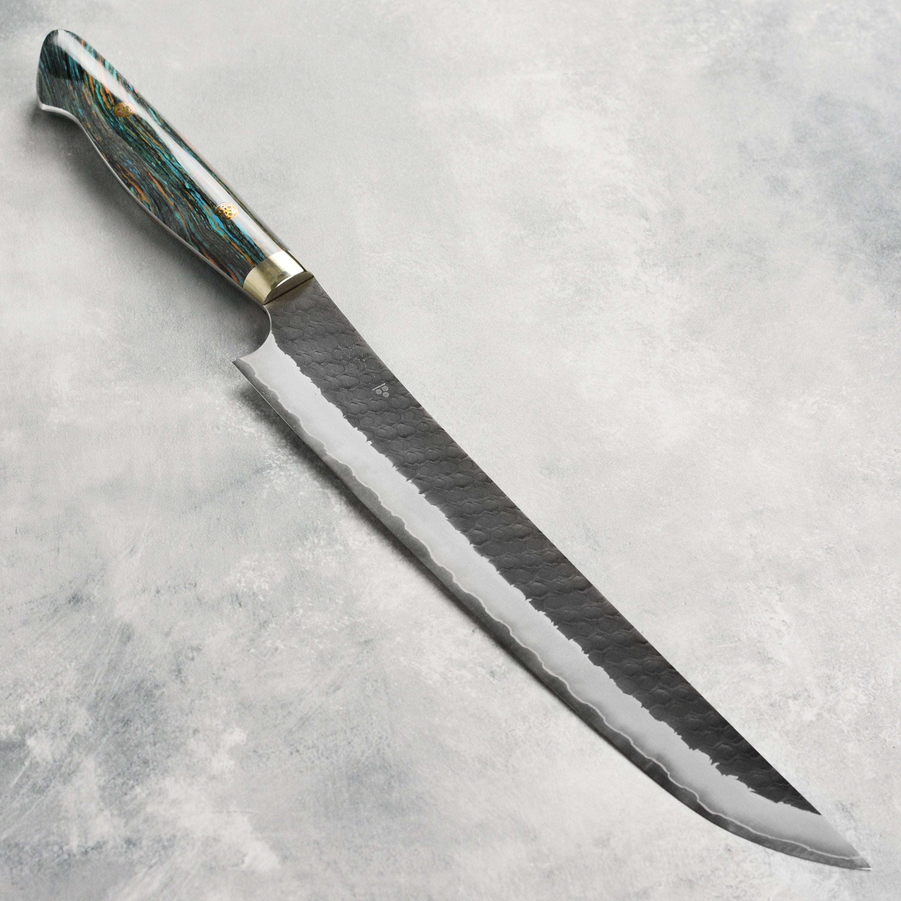 Side view of the Nigara Japanese kitchen knife with striped turquoise handle, ideal for slicing.