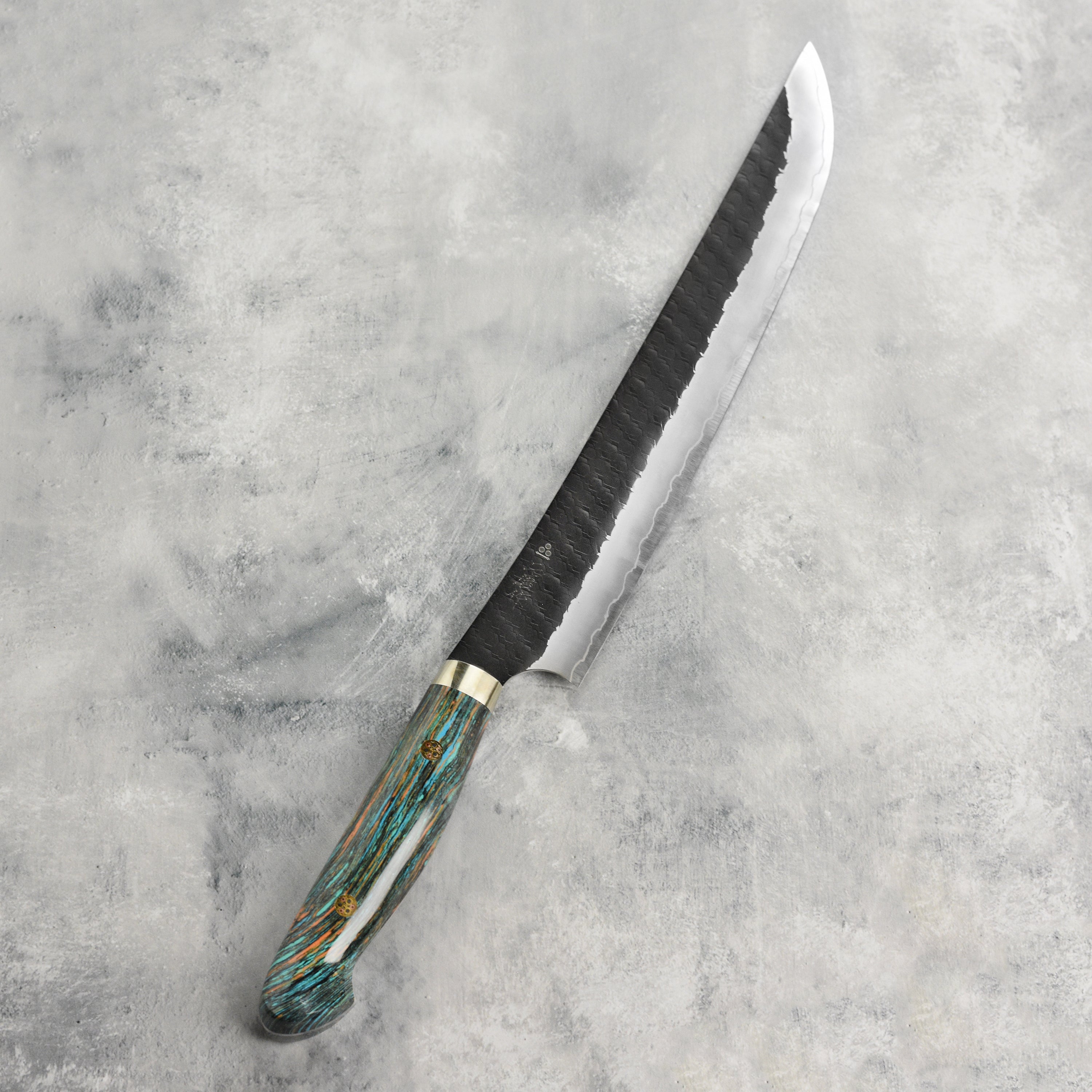 Top view of the 10.6-inch sujihiki knife highlighting its sharp edge and kurouchi finish.