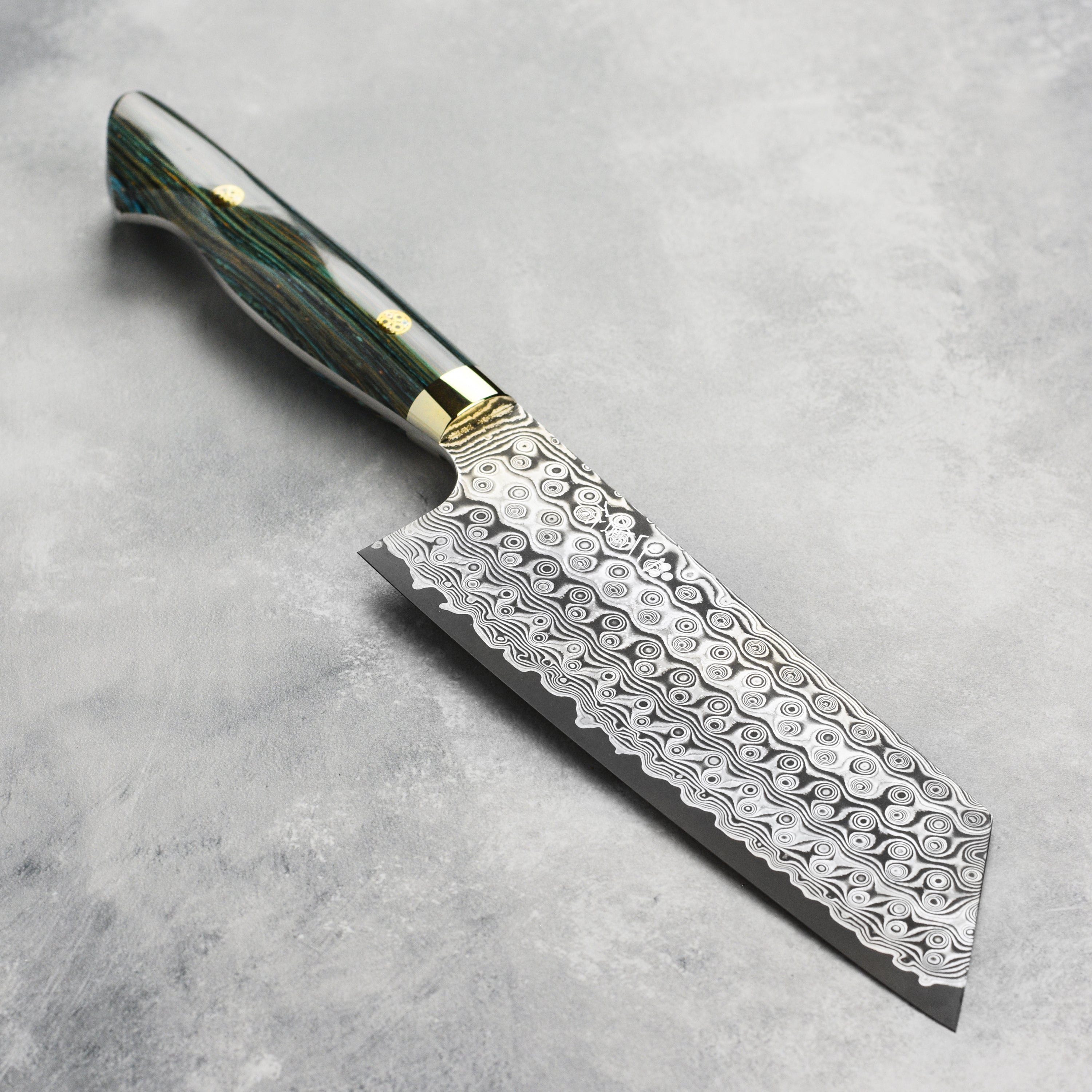 Close-up view of the turquoise striped Damascus kiritsuke knife showcasing its sharp edge and craftsmanship.