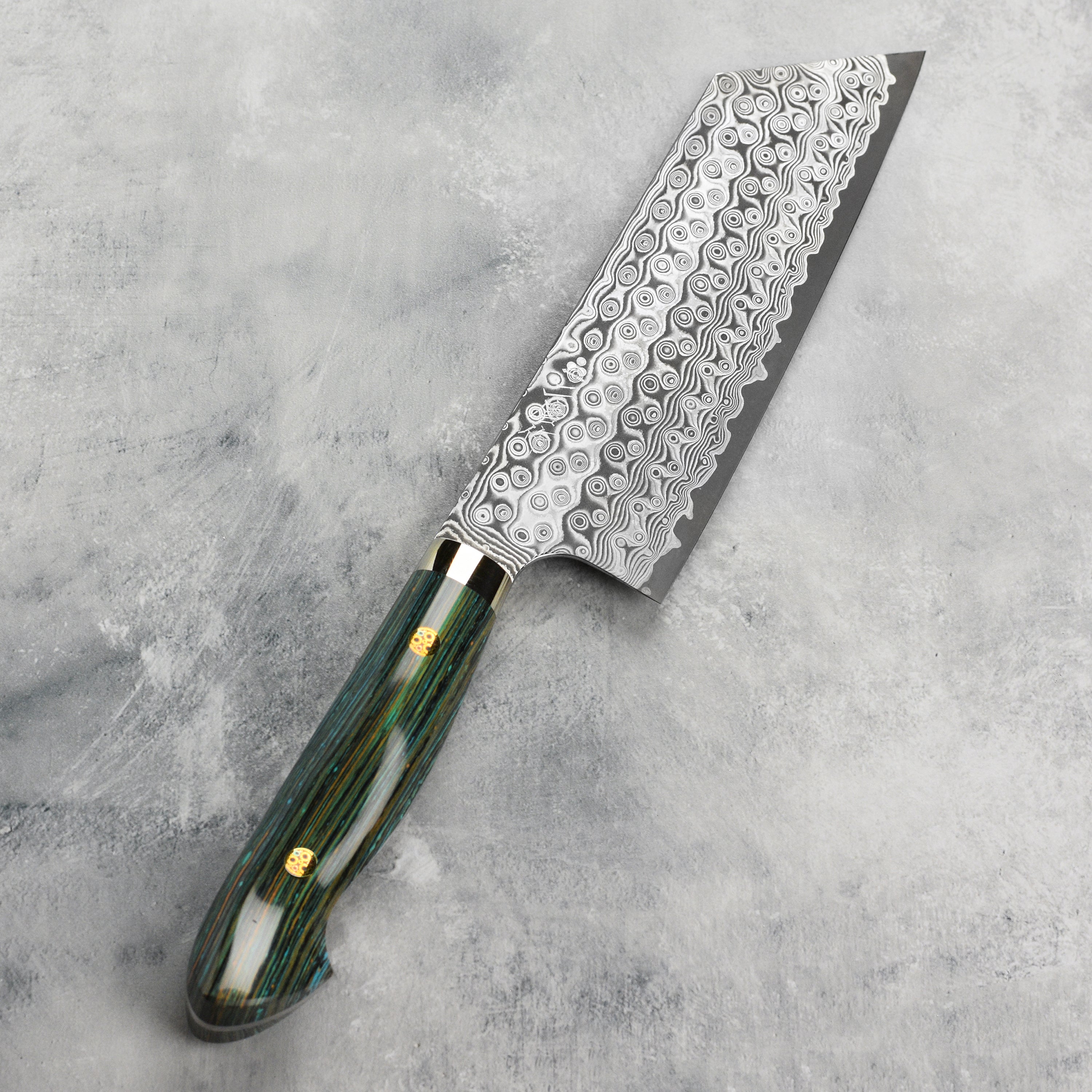 Close-up view of the turquoise striped Damascus kiritsuke knife showcasing its sharp edge and craftsmanship.