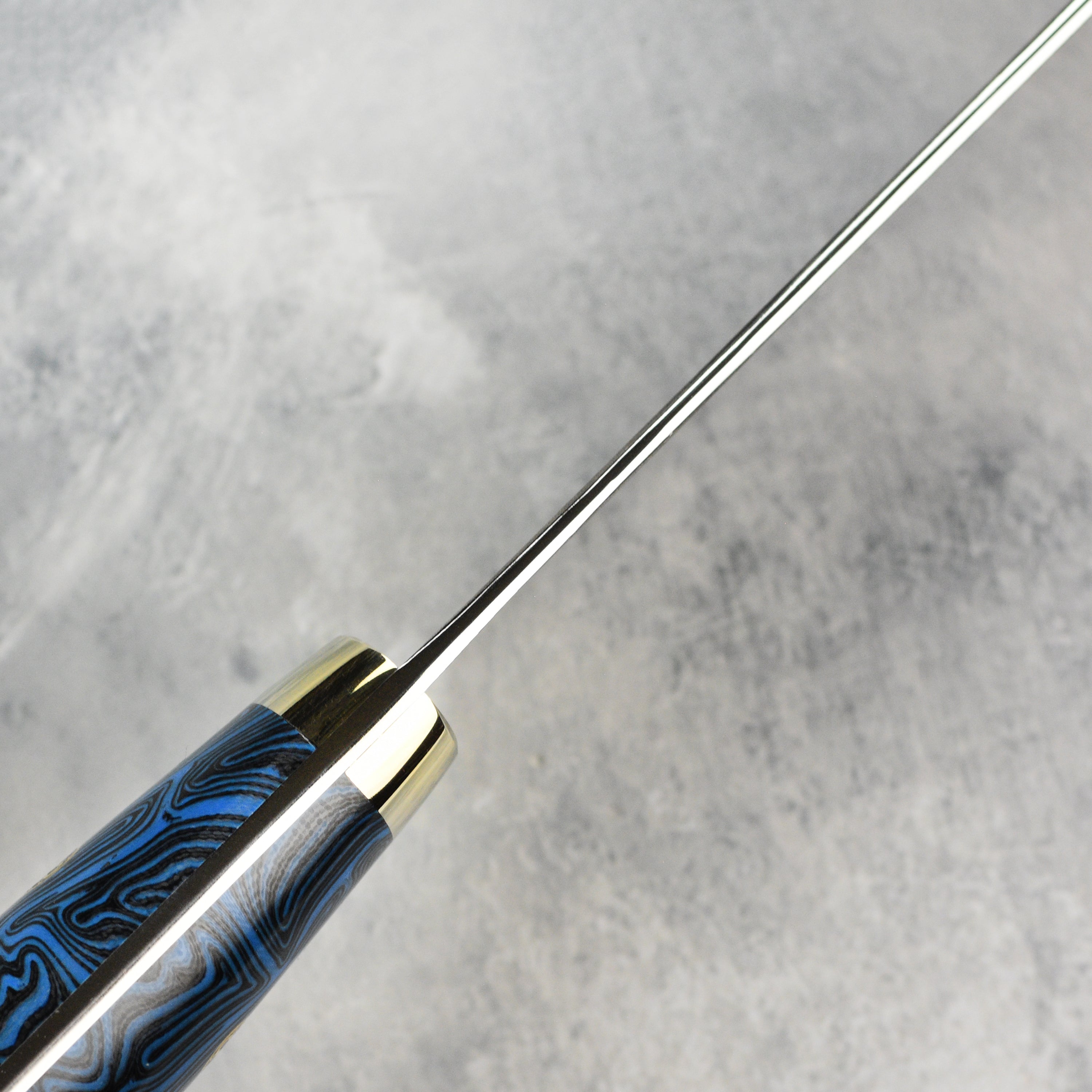Close-up of the Damascus pattern and sharp edge of the gyuto knife
