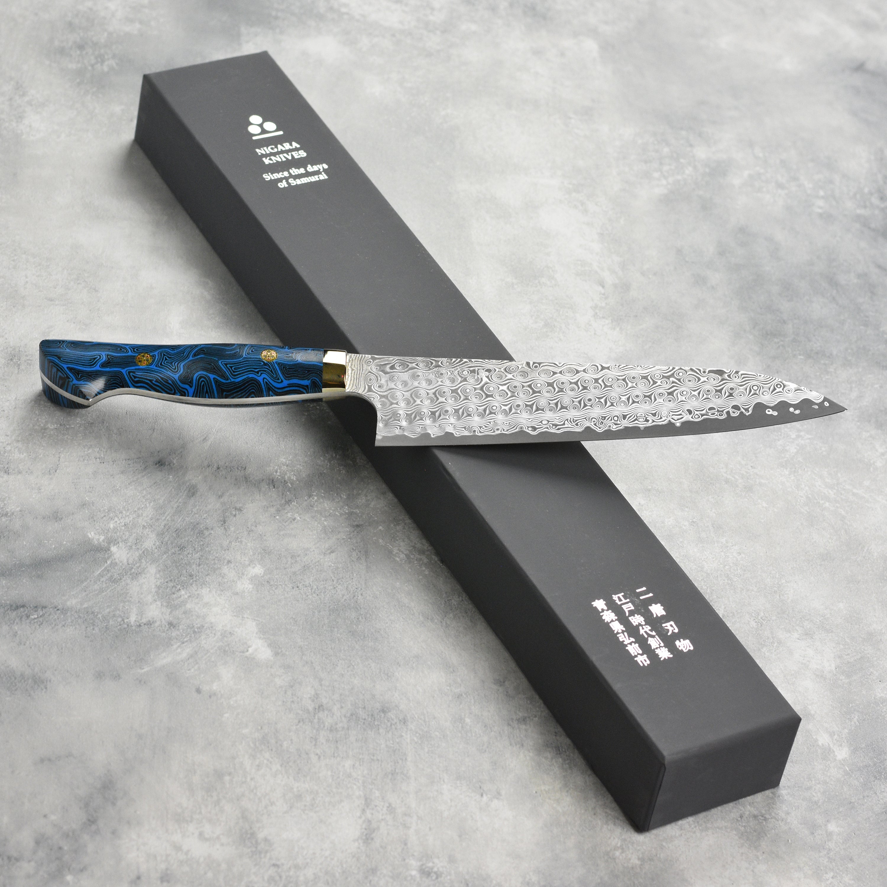 Top view of Nigara Anmon SG2 Damascus gyuto knife with G10 handle for precise slicing