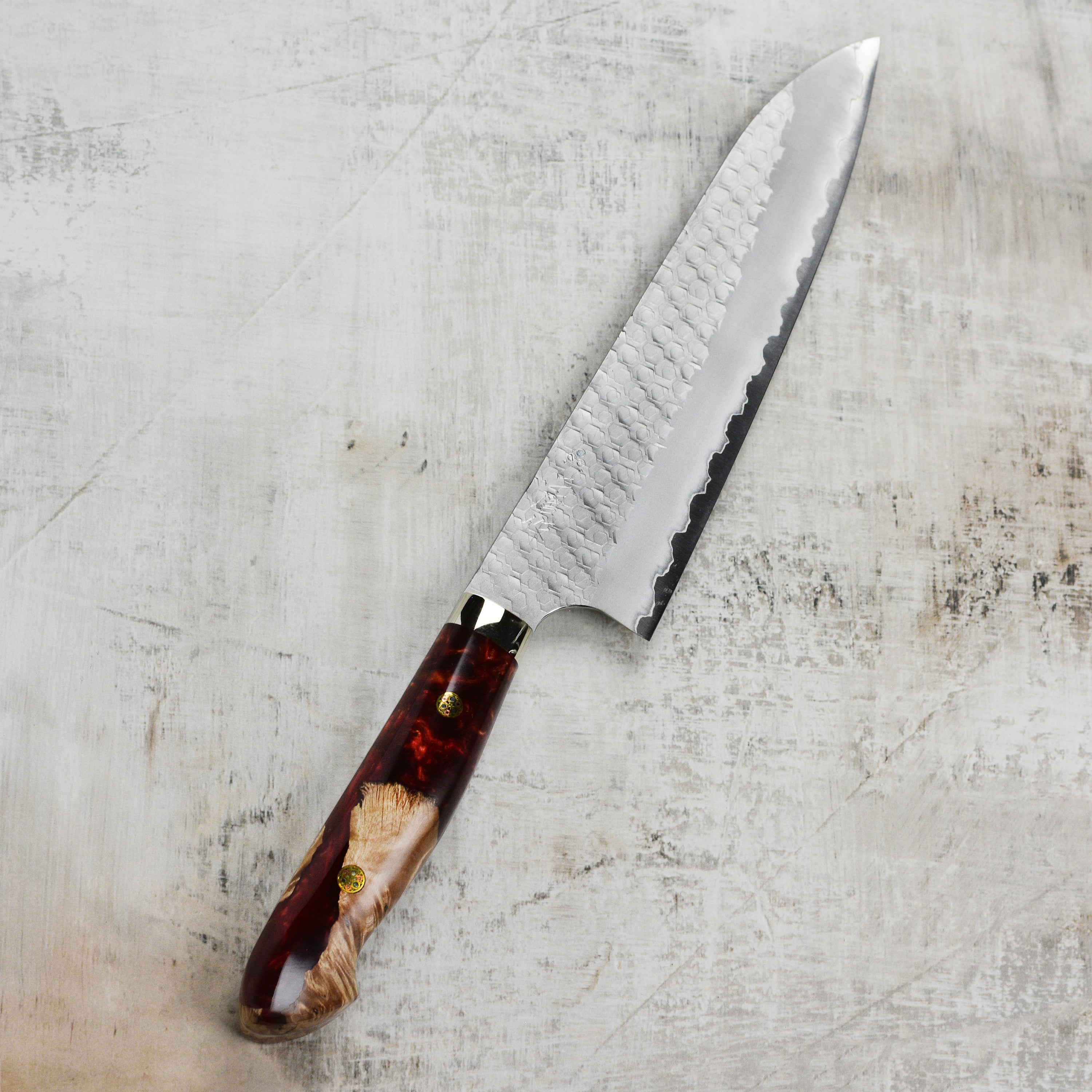 Crimson Edge Gyuto knife in use, demonstrating its performance on vegetables and meats in a professional kitchen.