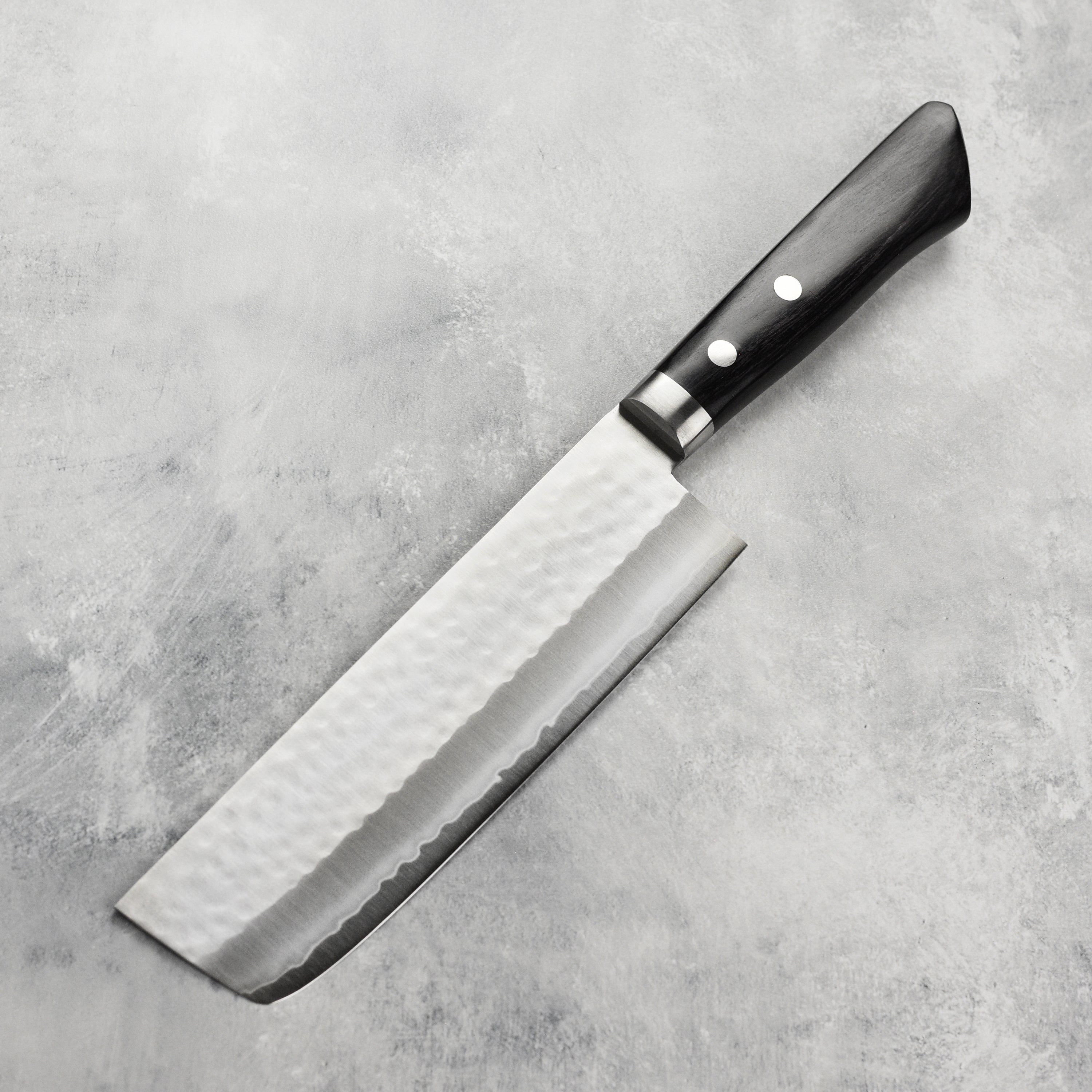 Masutani VG1 nakiri knife with hammered finish and black handle, showcasing the craftsmanship.