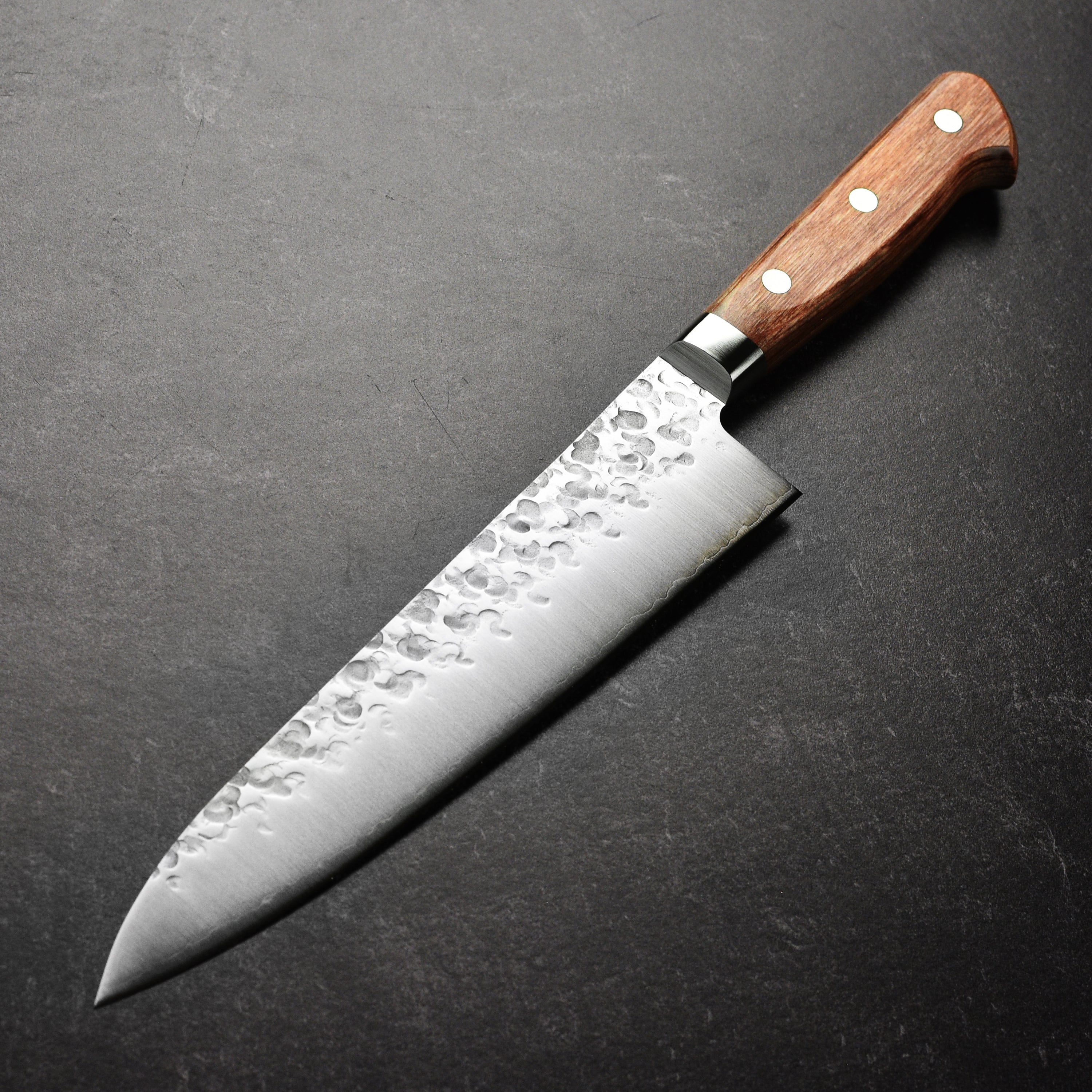 Takamura Chromax Tsuchime Gyuto Knife in use, slicing through vegetables with ease and precision.