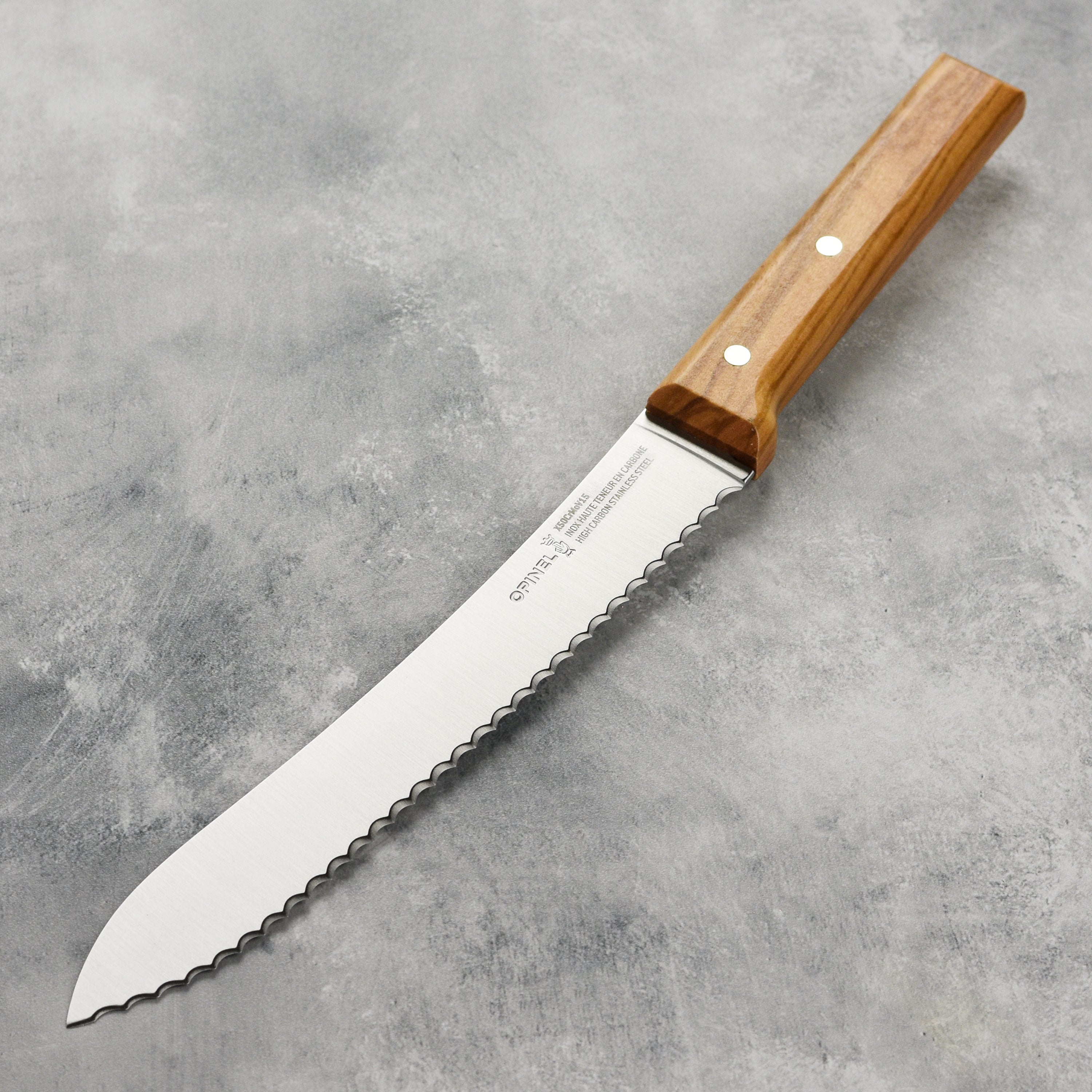 Opinel olivewood bread knife slicing fresh bread with serrated edge